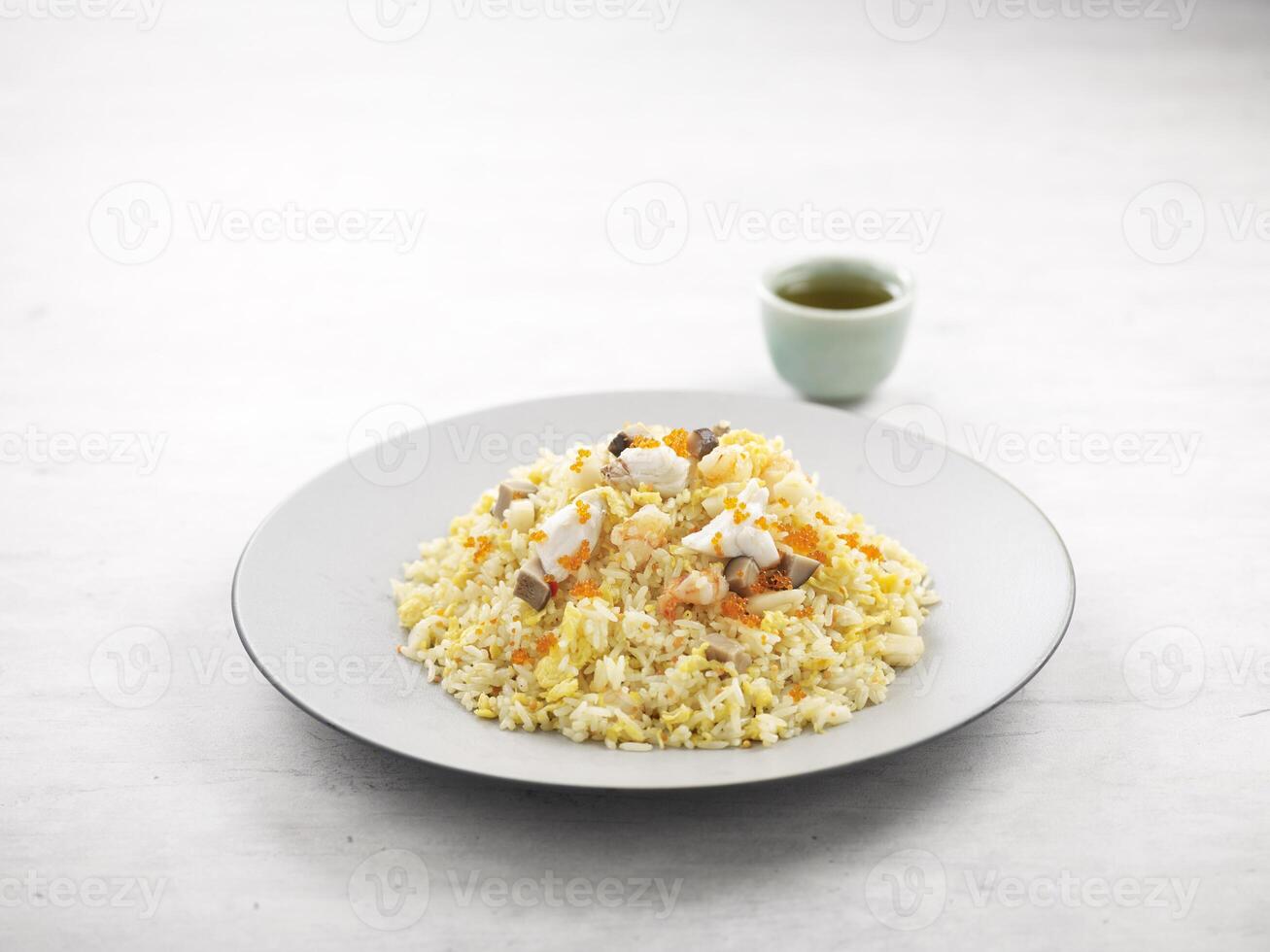 Fried Rice with Seafood and Ebiko served in a dish side view on grey background photo