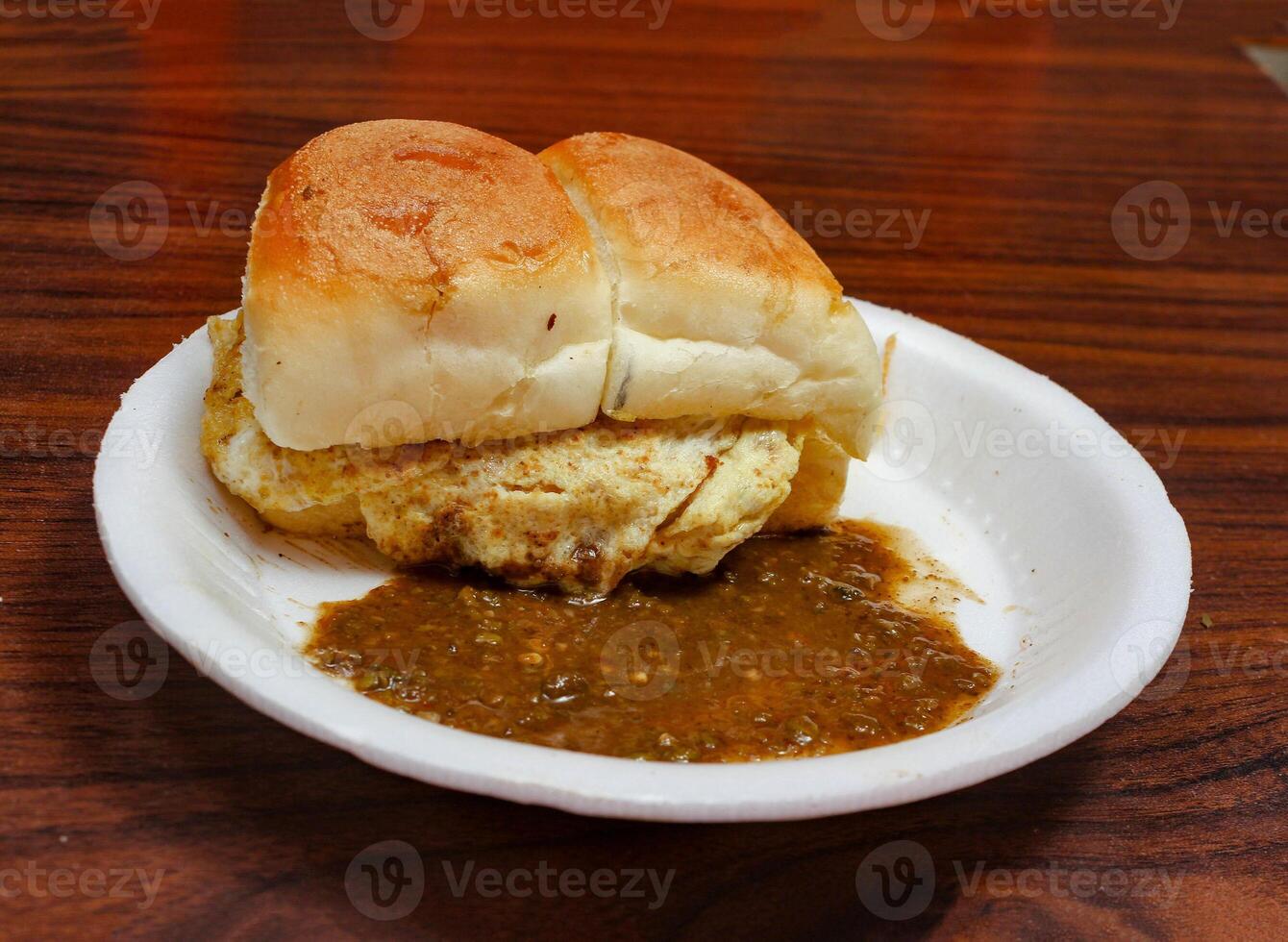 Sauth asian food Bread Bun With Eggs Kabab With Tomato Sauce and Spicy Chutney in white plate isolated on dark wooden table famous Pakistani, Indian, Bangladeshi food photo