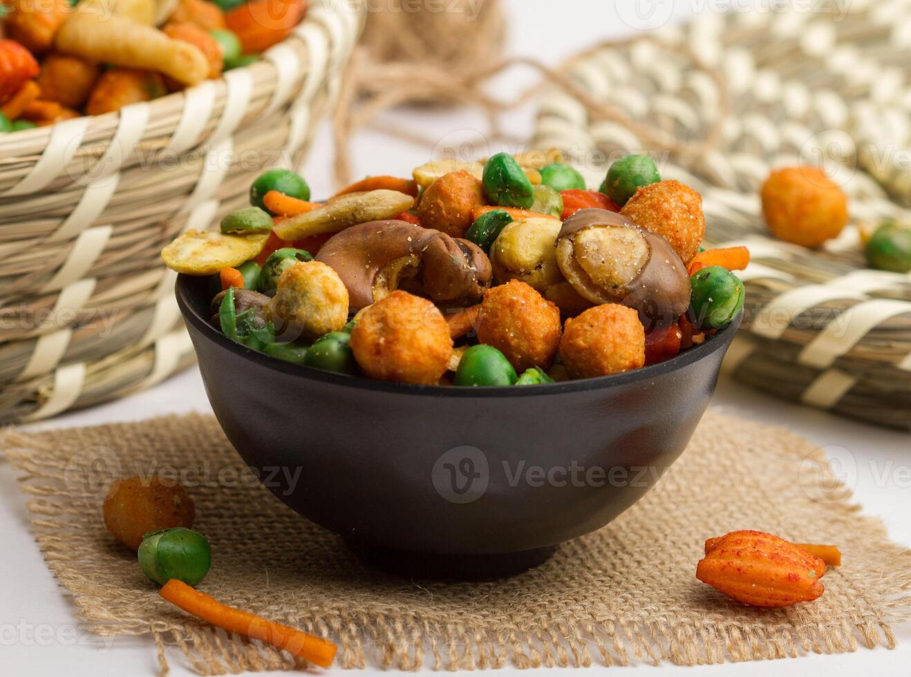 chinese mixed crackers served in a bowl isolated on napkin side view of nuts on grey background photo