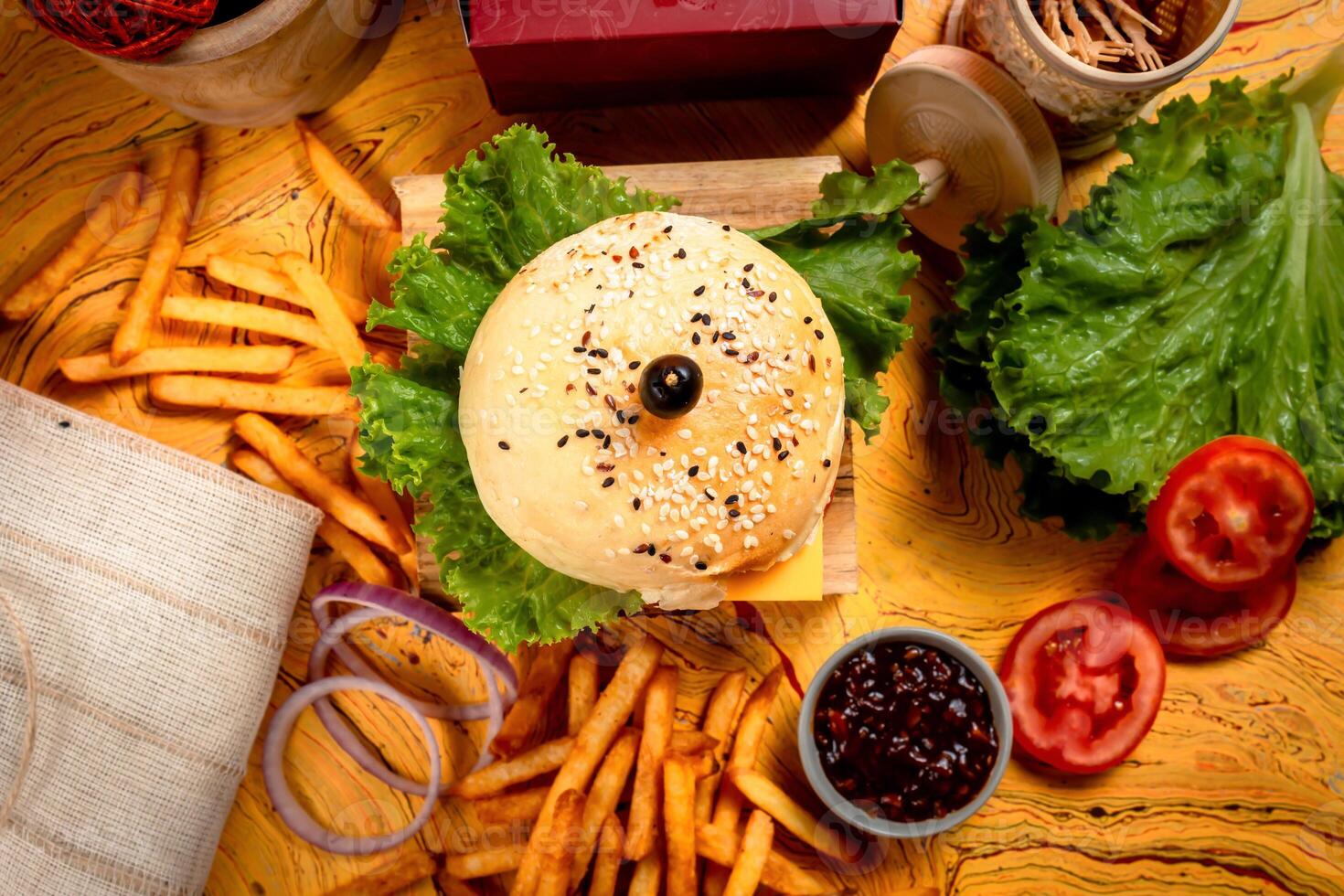 BBQ Beef Cheese burger with french fries, potato and tomato slice isolated on wooden board top view on table fast food photo