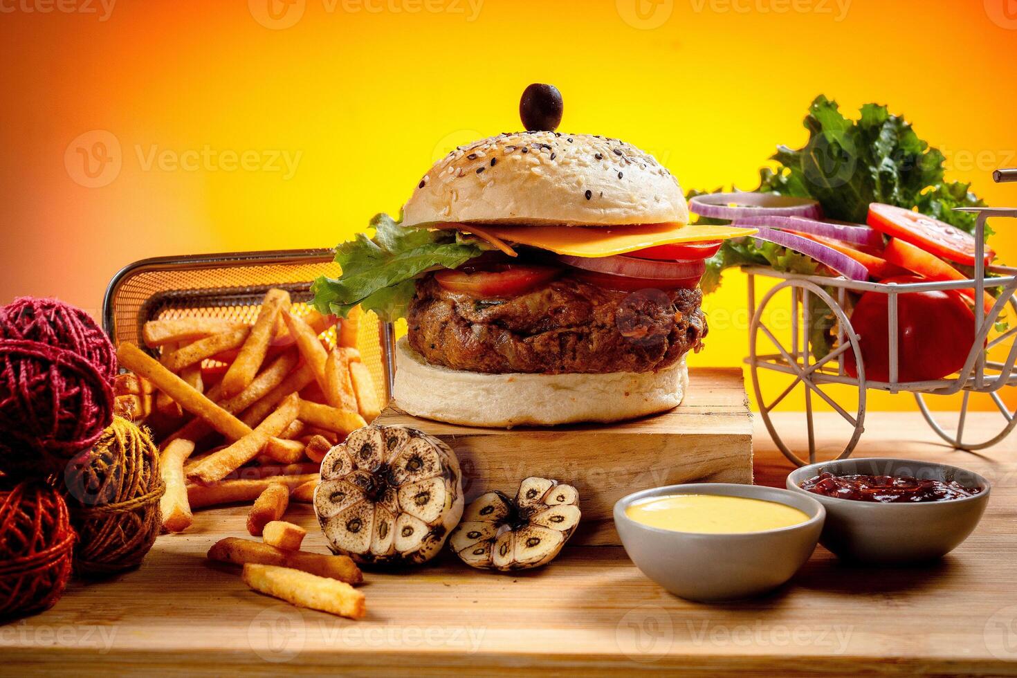 Beef Cheese burger with french fries, potato and tomato slice isolated on wooden board slide view on table fast food photo