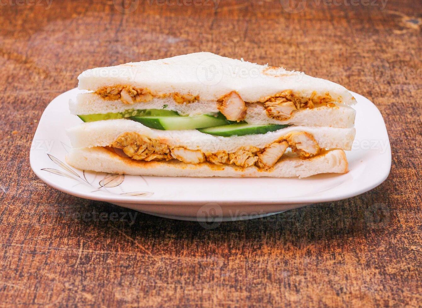 chicken tikka sandwich in a dish on dark wooden background side view photo