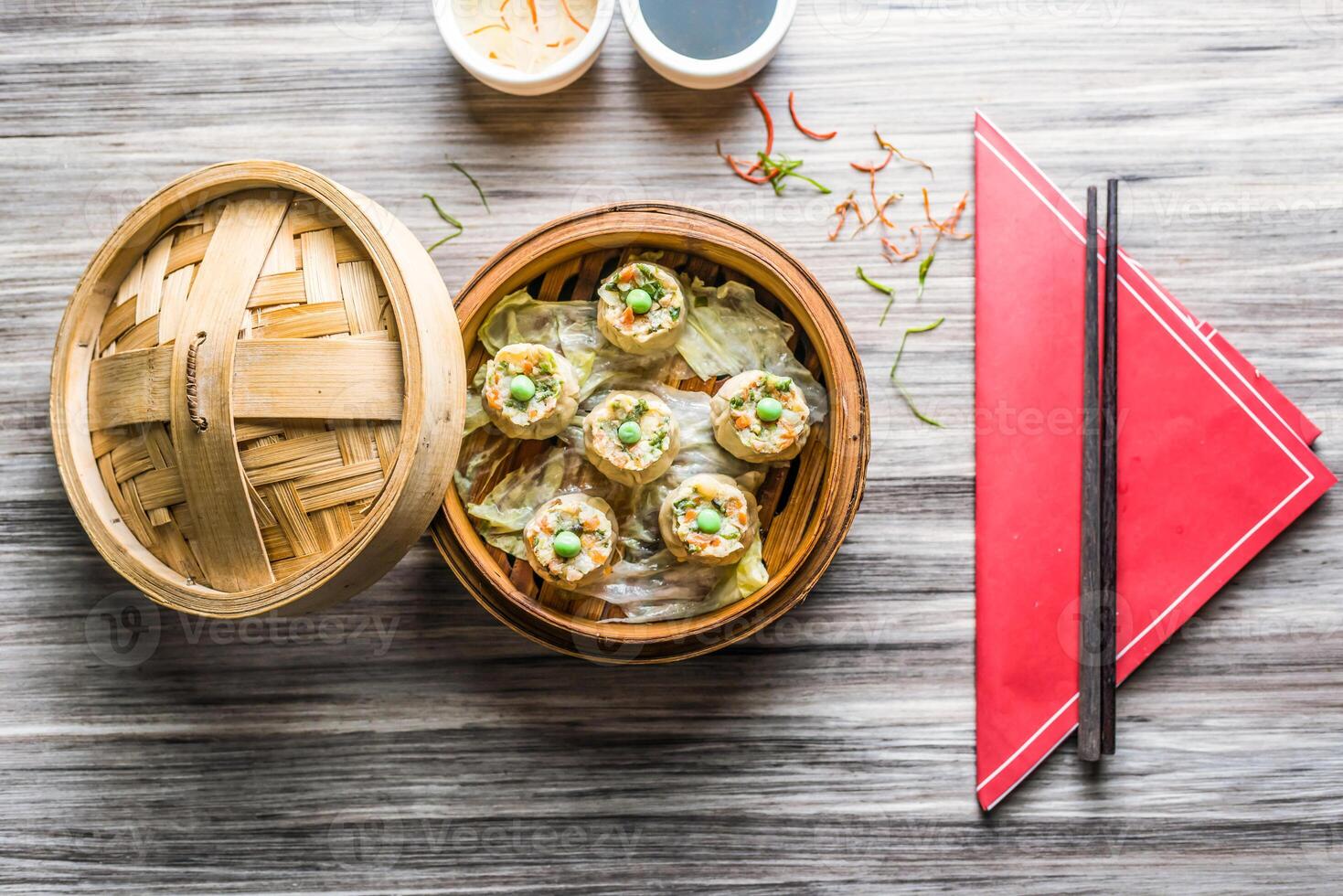 Vegetable Sui Mai with sauce and chopsticks isolated on wooden board top view on table fastfood photo