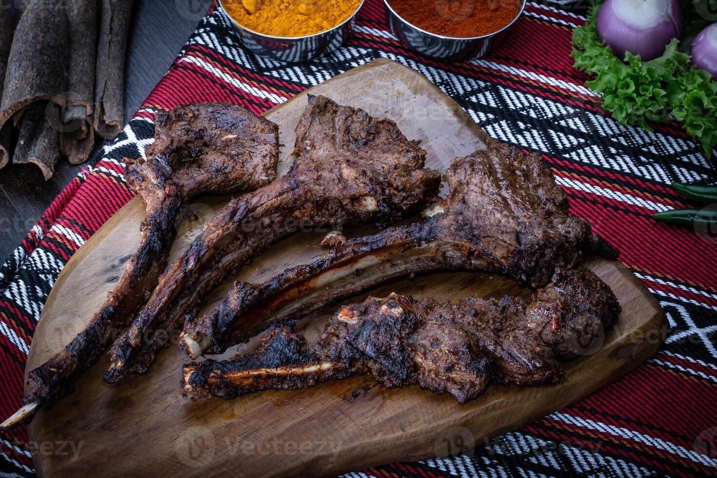 Charcoal Grilled Lamb Chops served in wooden board isolated on table top view of arabic food photo