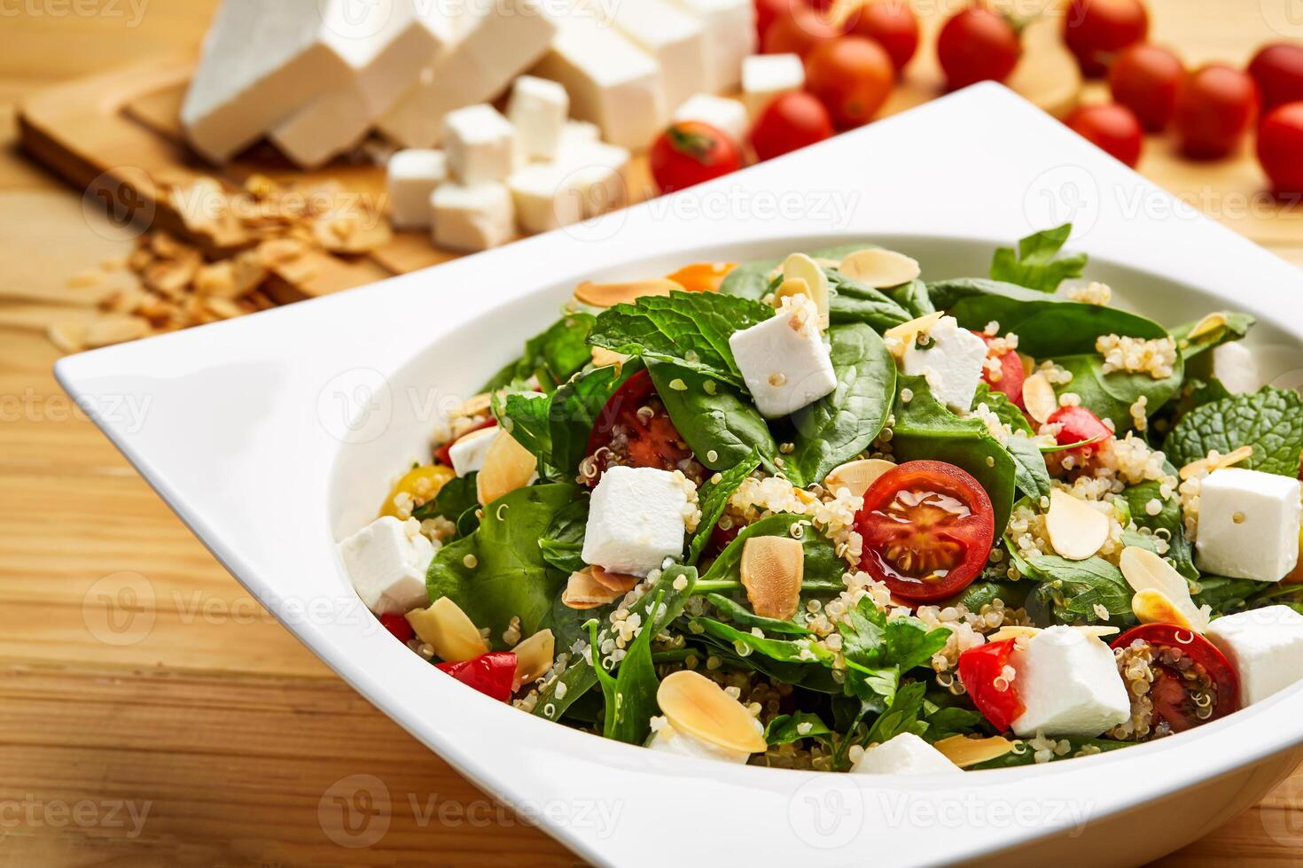 Superfood salad with cherry tomato, cucumber, basil leave and herbs served in dish isolated on wooden table with raw food top view of super healthy appetizer food photo