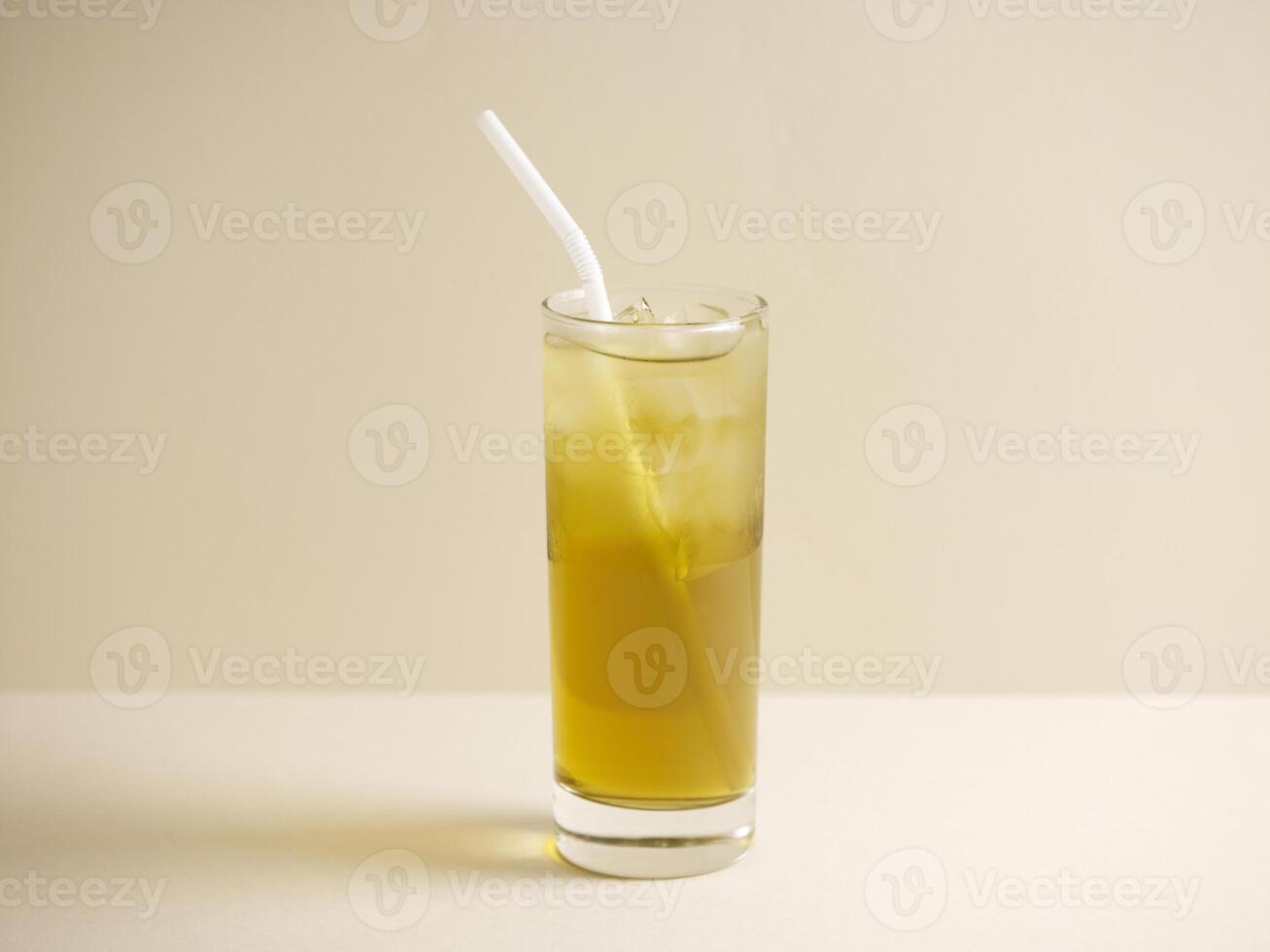 A glass of Watercress Honey Lemon Drink with straw isolated on grey background side view photo