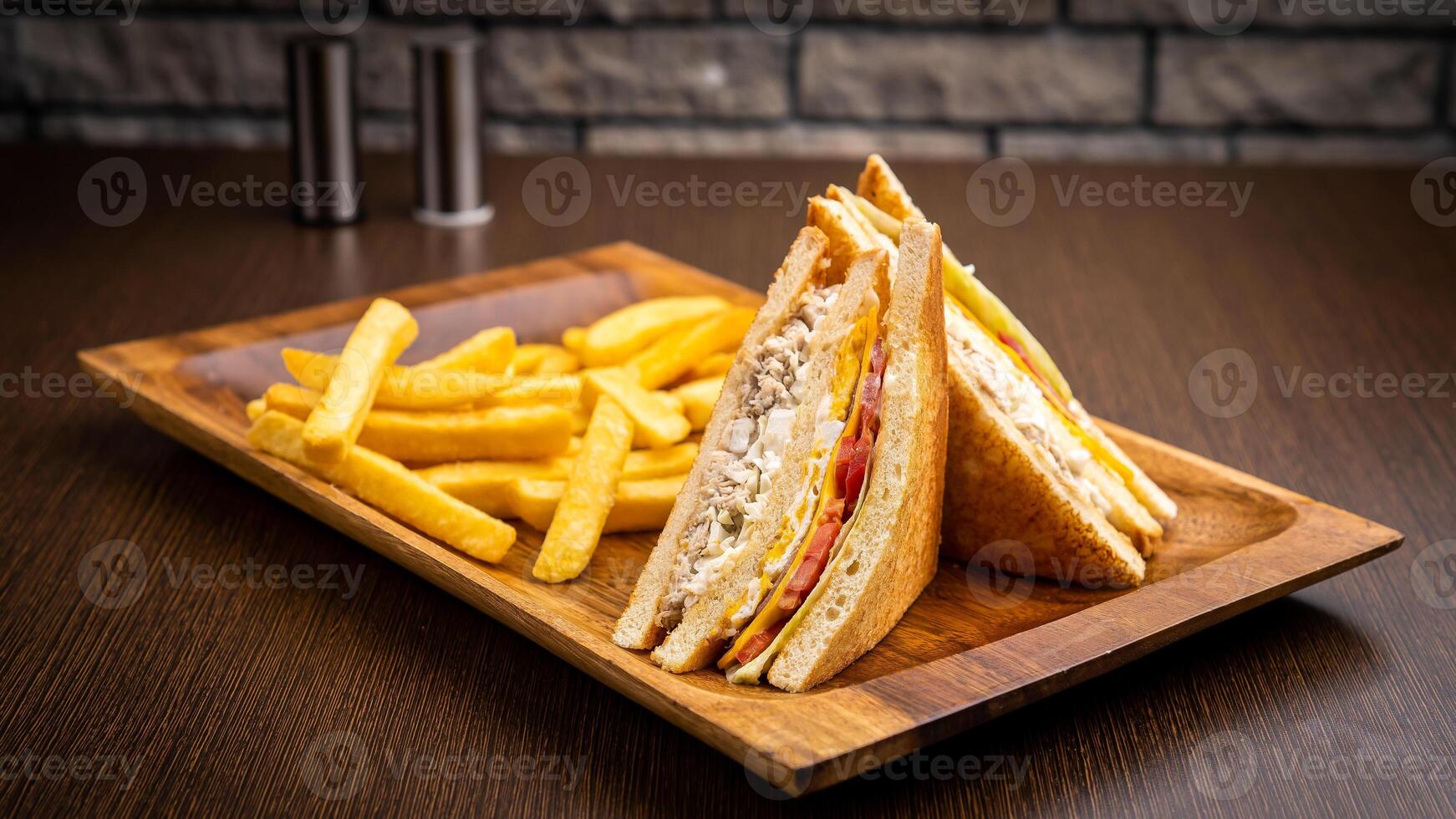 club sandwich and fries isolated on wooden board side view on table fast food photo