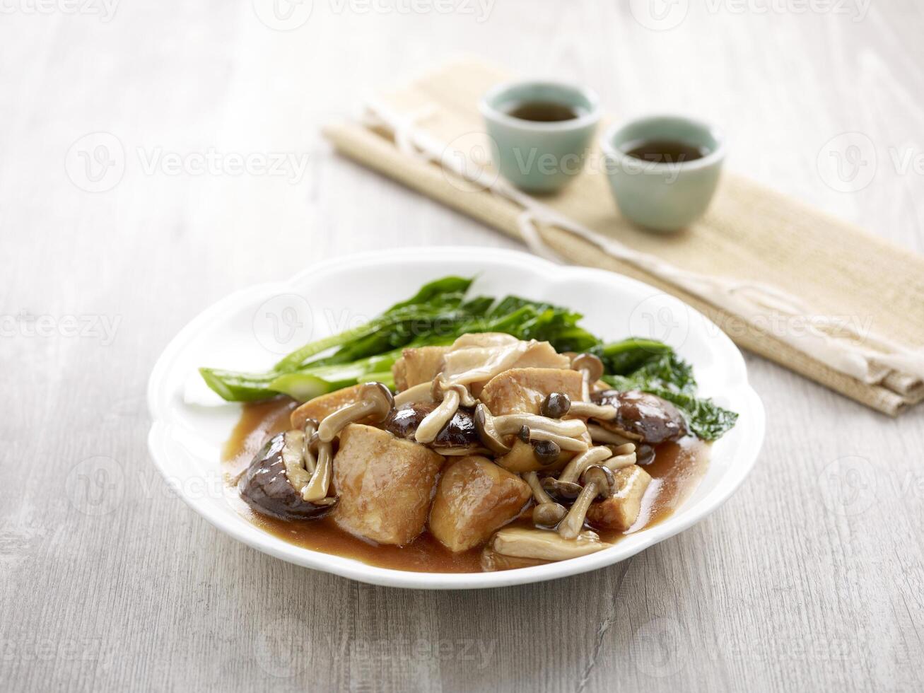 cocido a fuego lento firma tofu con clasificado hongos con palillos servido en un plato aislado en estera lado ver en gris antecedentes foto