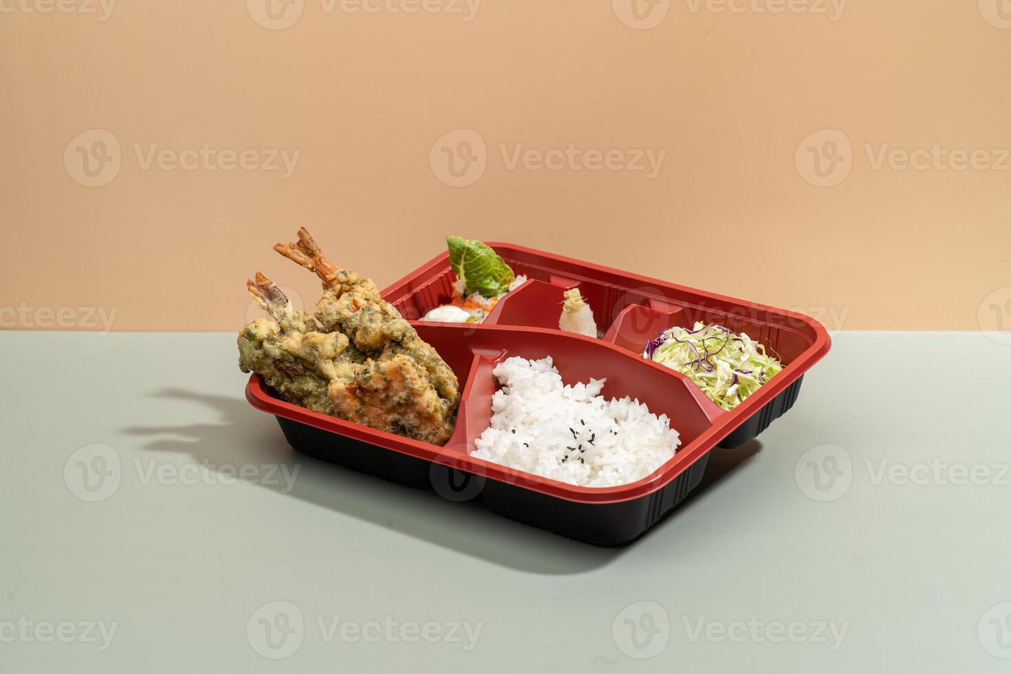 MIXED TEMPURA regular BENTO with sauce and chopsticks isolated on red background side view of japanese fast food photo