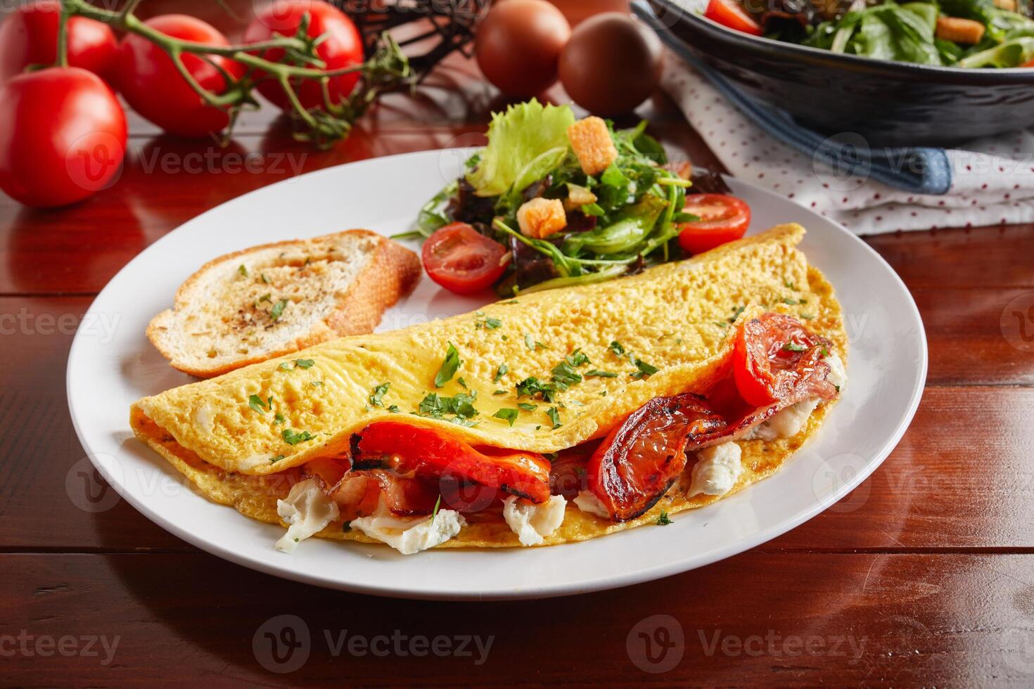 Greek Style cream sauce omelette roll with salad served in a dish isolated on wooden background side view photo