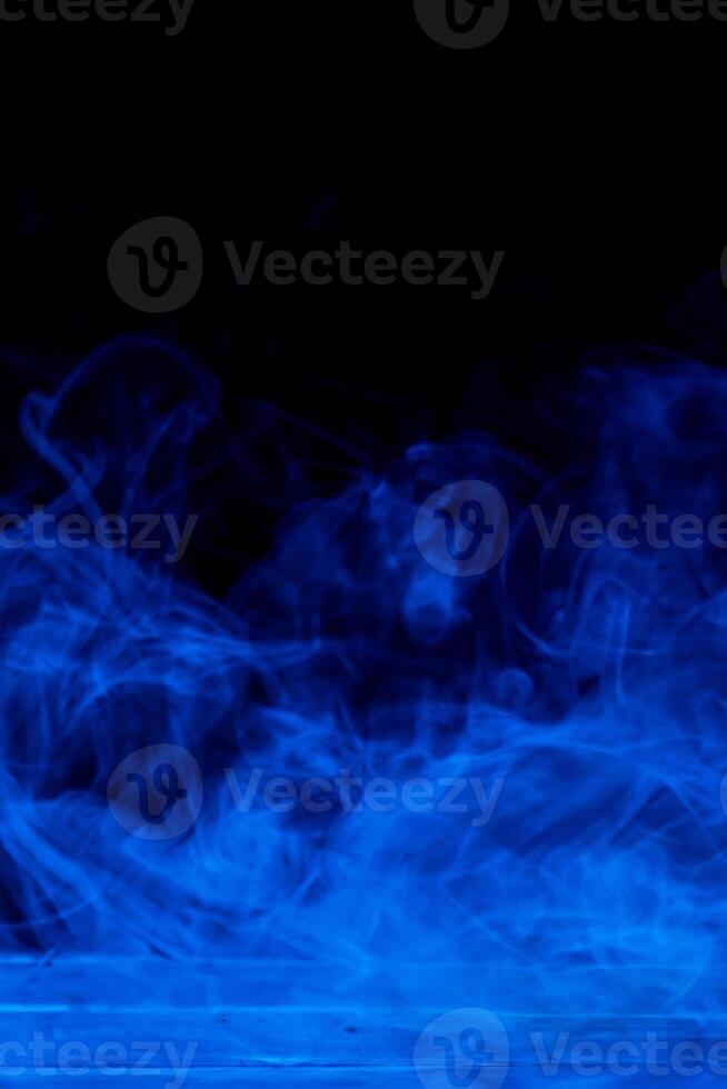 Abstract Blue Smoke Concept, Isolated on Dark Black Background with Wooden Table photo