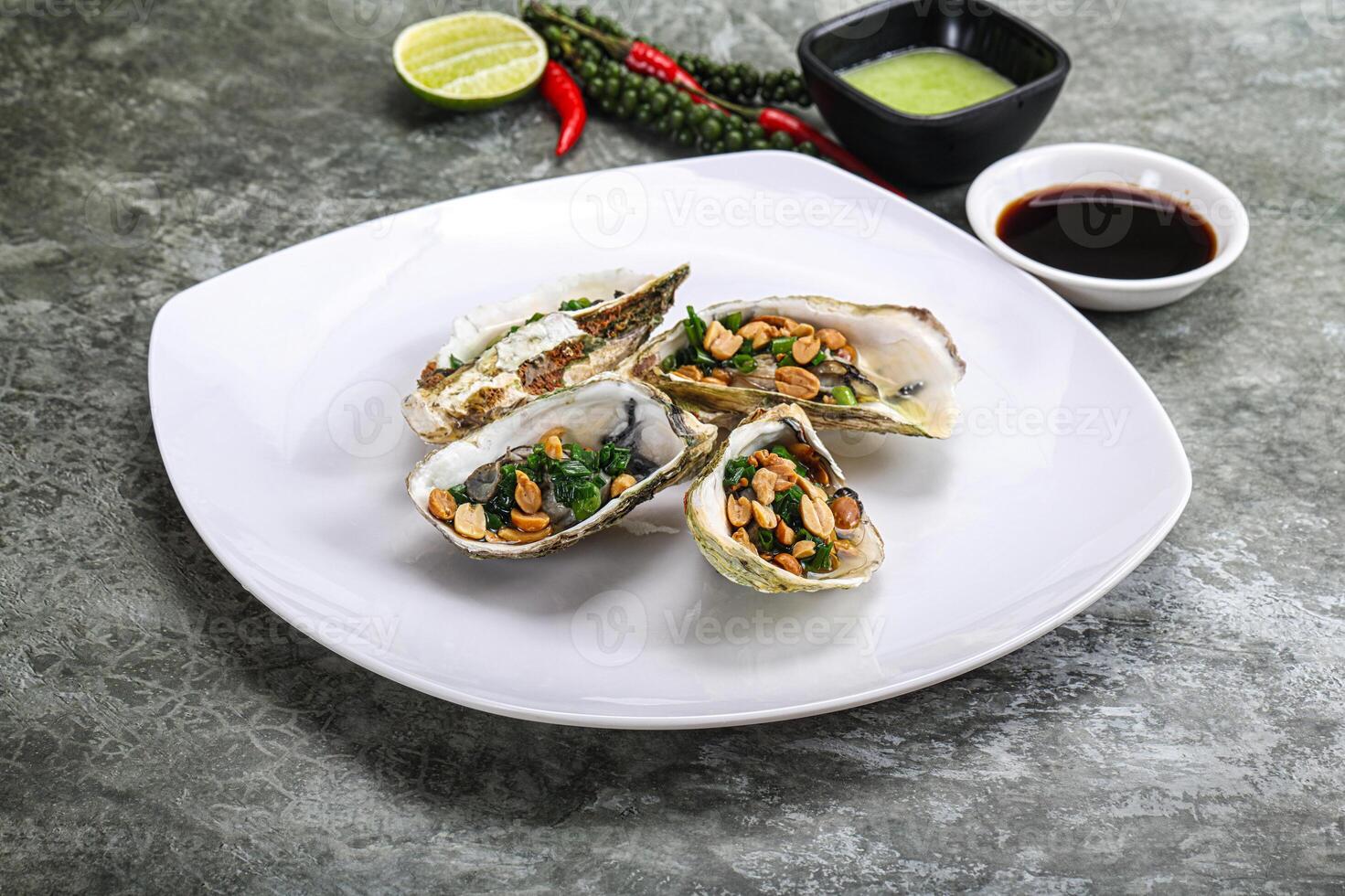 Open half oysters with green onion photo