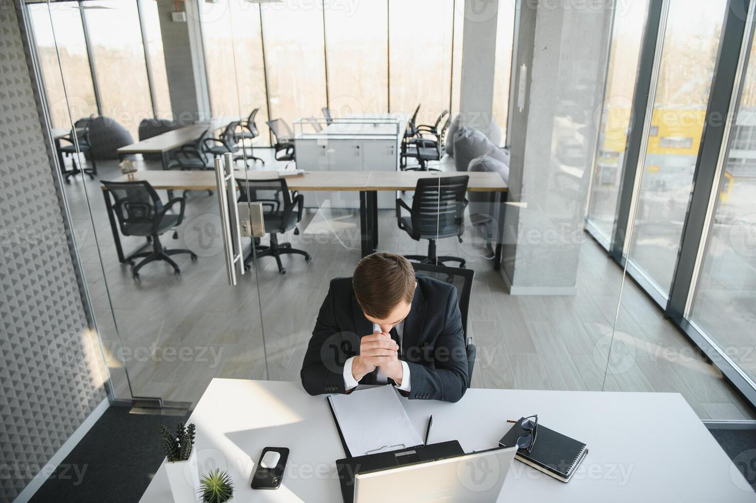 retrato de estresado fuera y preocupado molesto sobrecargado de trabajo empresario empresario mirando documentos reporte en moderno brillante oficina trabajando debajo presión y apretado fecha límite foto