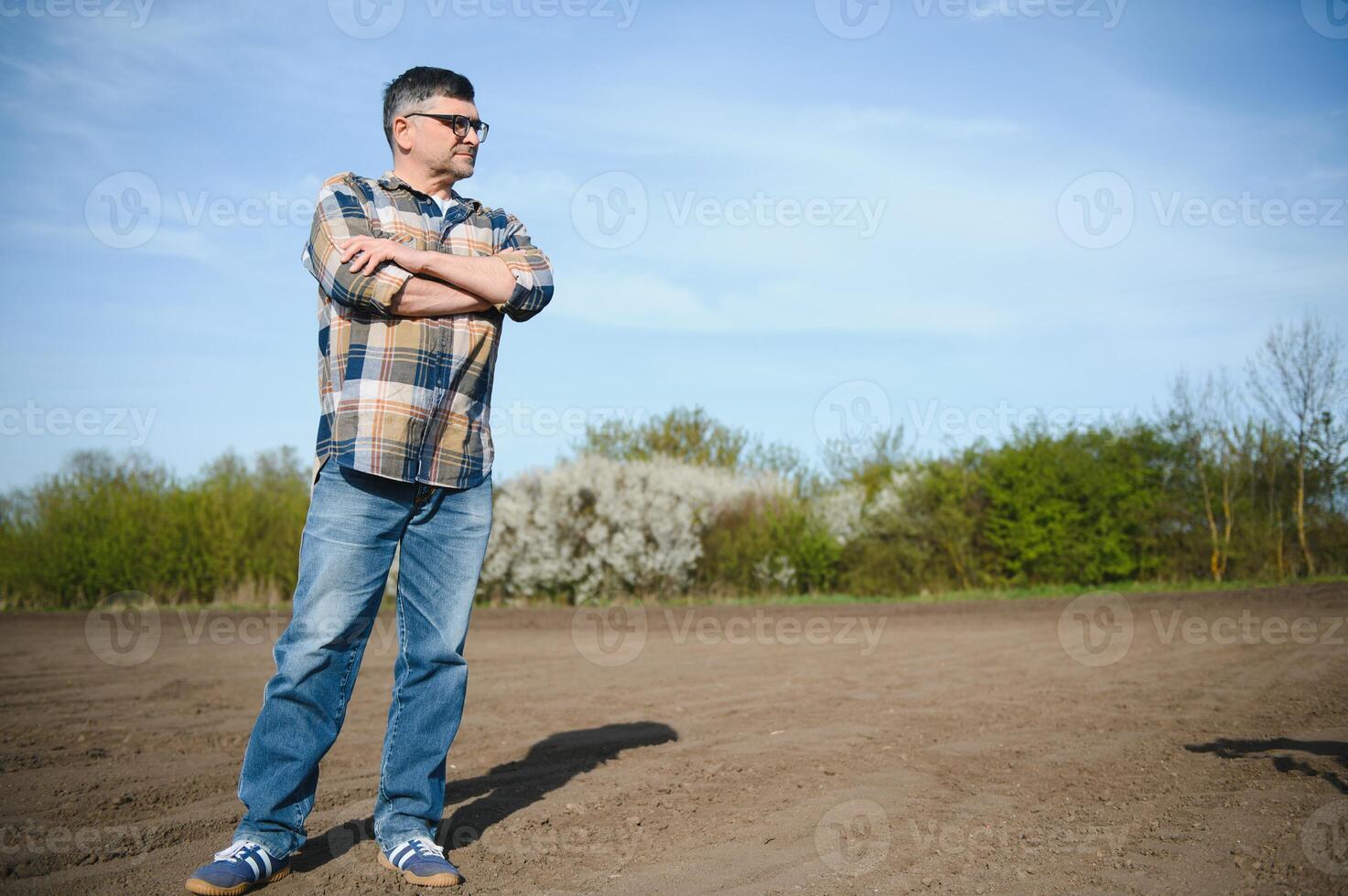 A farmer works in a field sown in spring. An agronomist walks the earth, assessing a plowed field in autumn. Agriculture. Smart farming technologies. photo