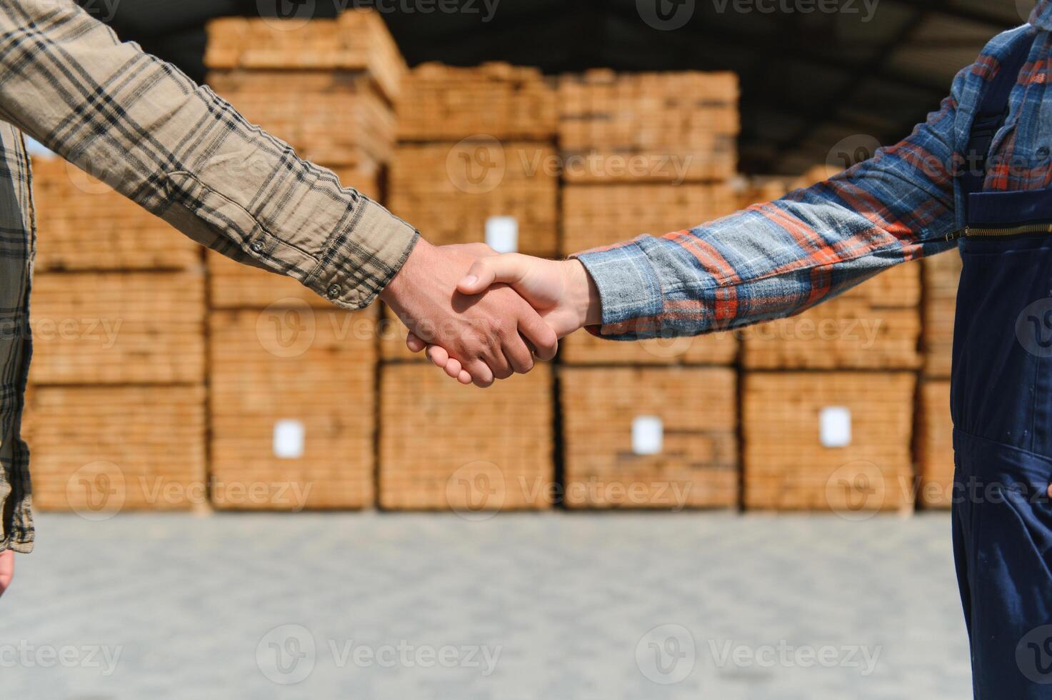 el concepto de de venta madera materiales de cerca de un apretón de manos en el antecedentes de un composición de tableros foto