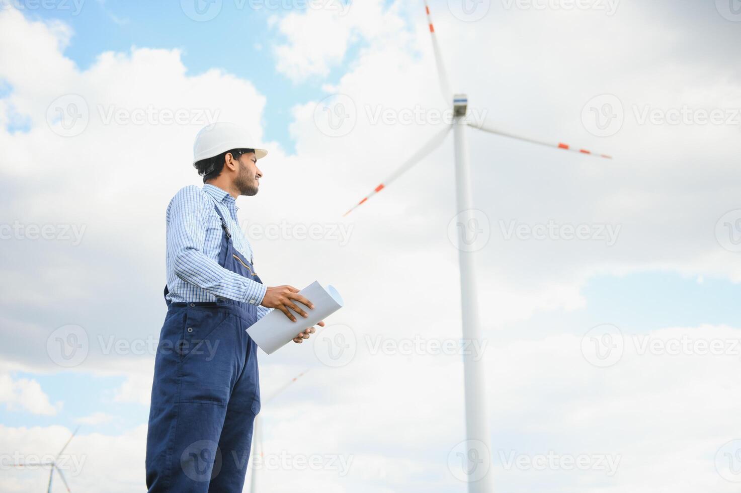 India ingeniero a molino granja operación a generar electricidad, asiático hombre trabajando a viento turbina granja, limpiar y verde energía. foto
