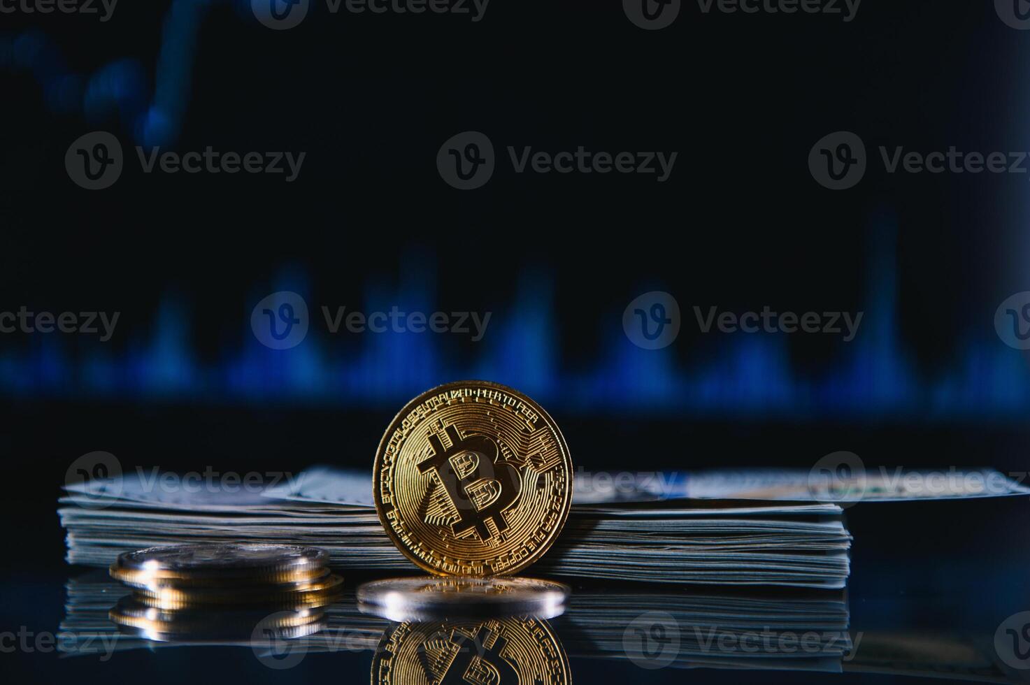 Golden bitcoin are stacked on a bright background of business graphs close-up. Bitcoin cryptocurrency. Folded in a tube 100 dollar bills photo