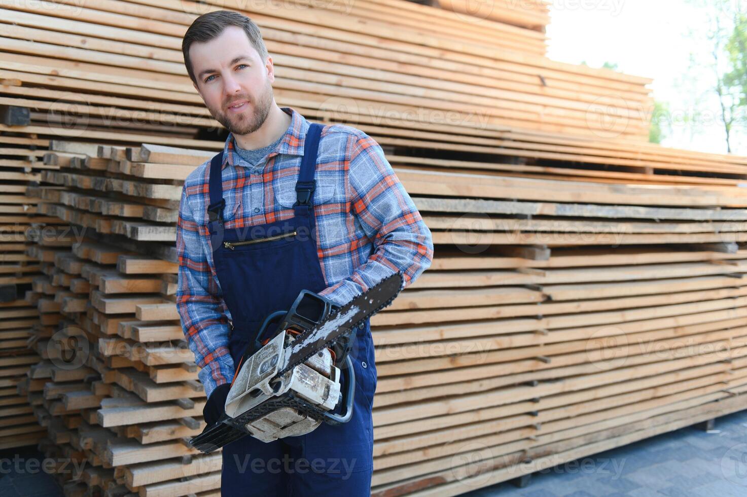 Carpenter in uniform check boards on sawmill photo