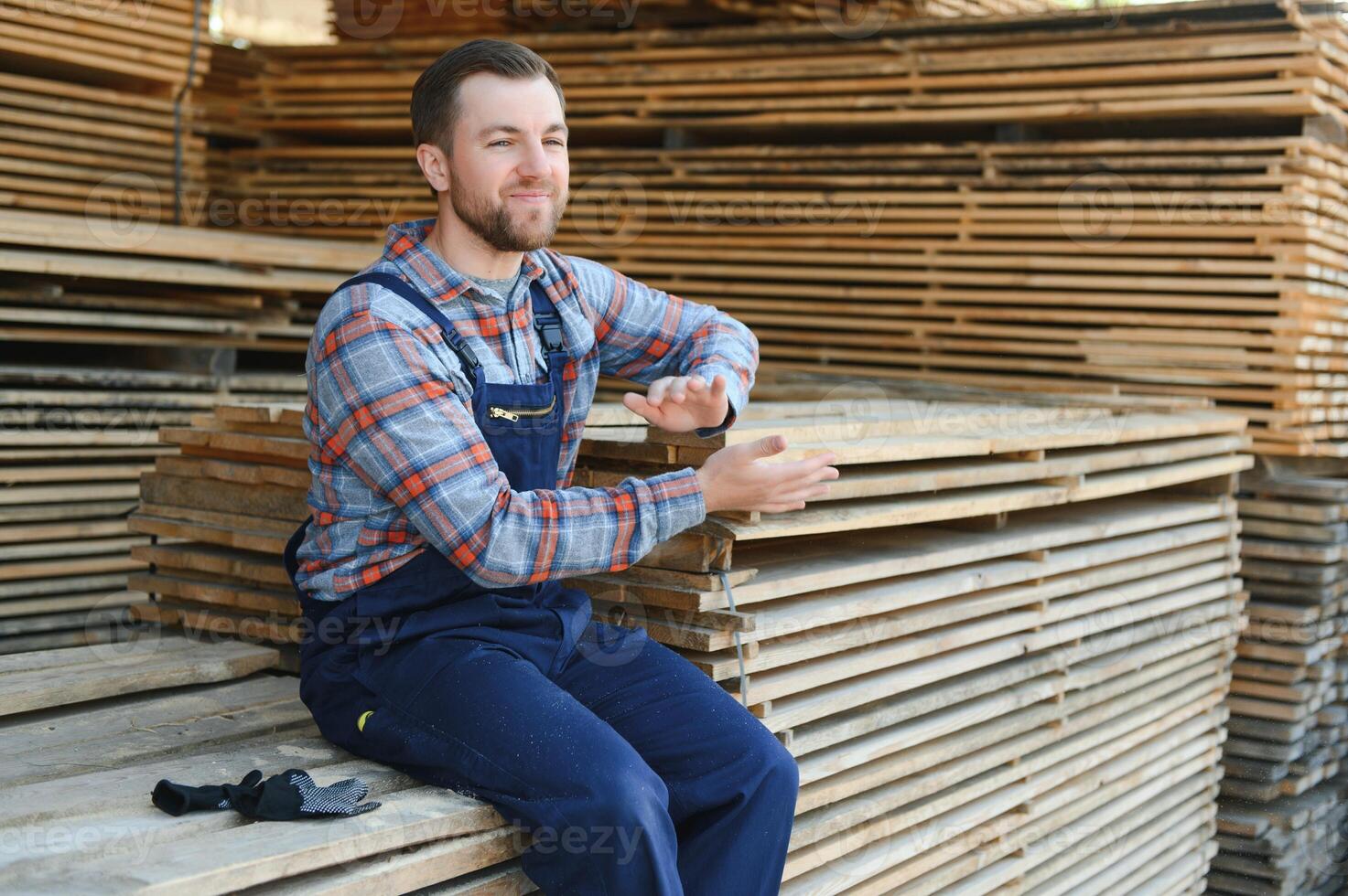 Male Worker folds boards. Sawmill. Wood harvesting process photo