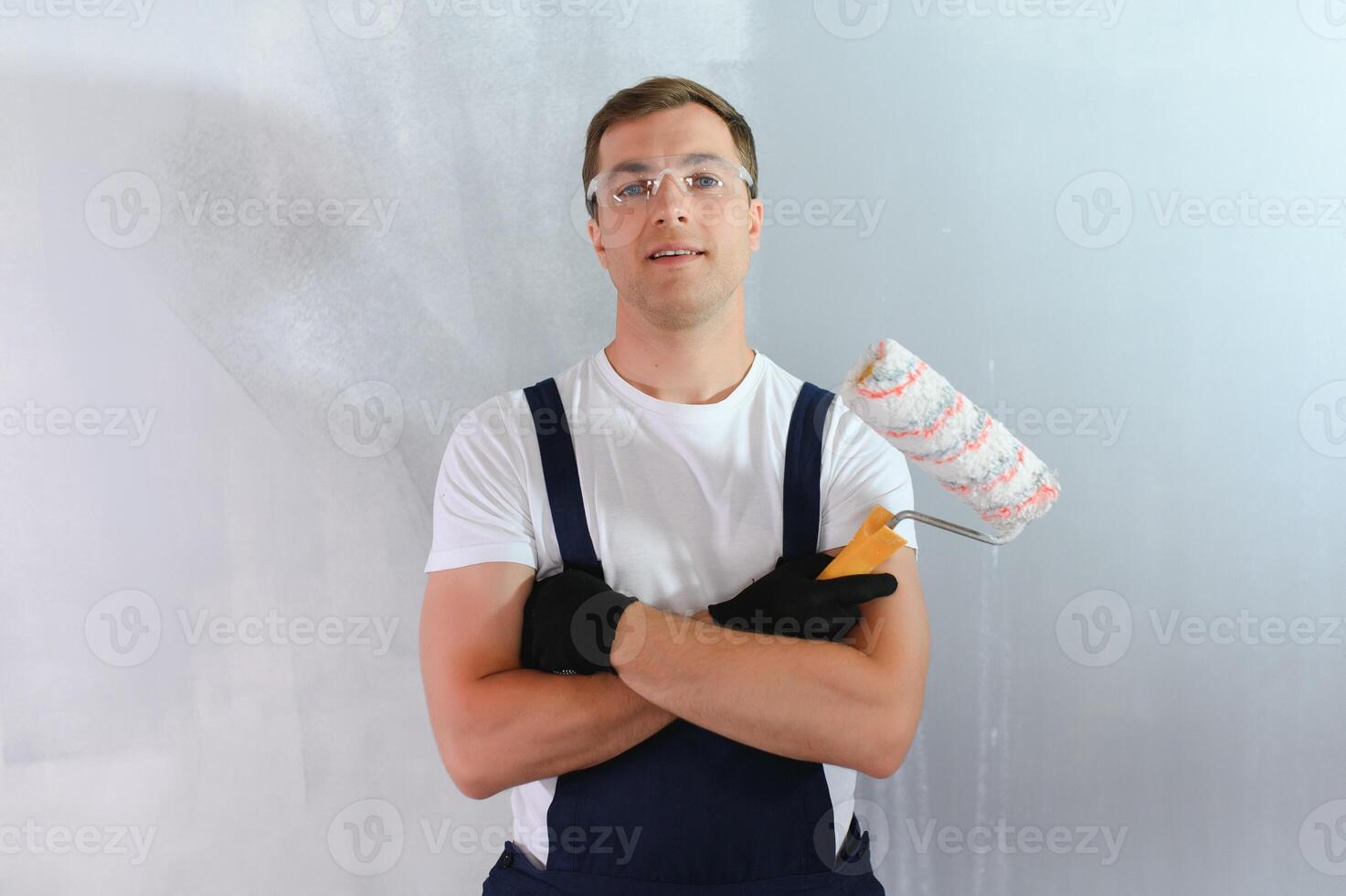 joven trabajador pintando la pared en la habitación foto