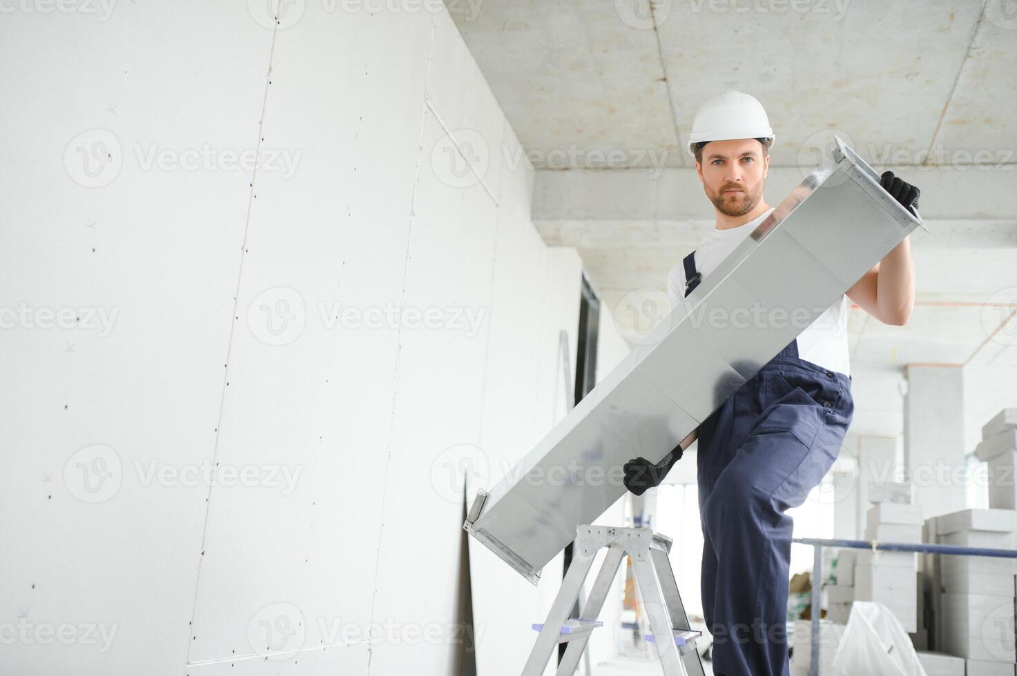 Industrial Theme. Warehouse Heating and Cooling System Installation by Professional Caucasian Technician. Commercial Building Ventilation Rectangle Canals. Air Distribution. photo