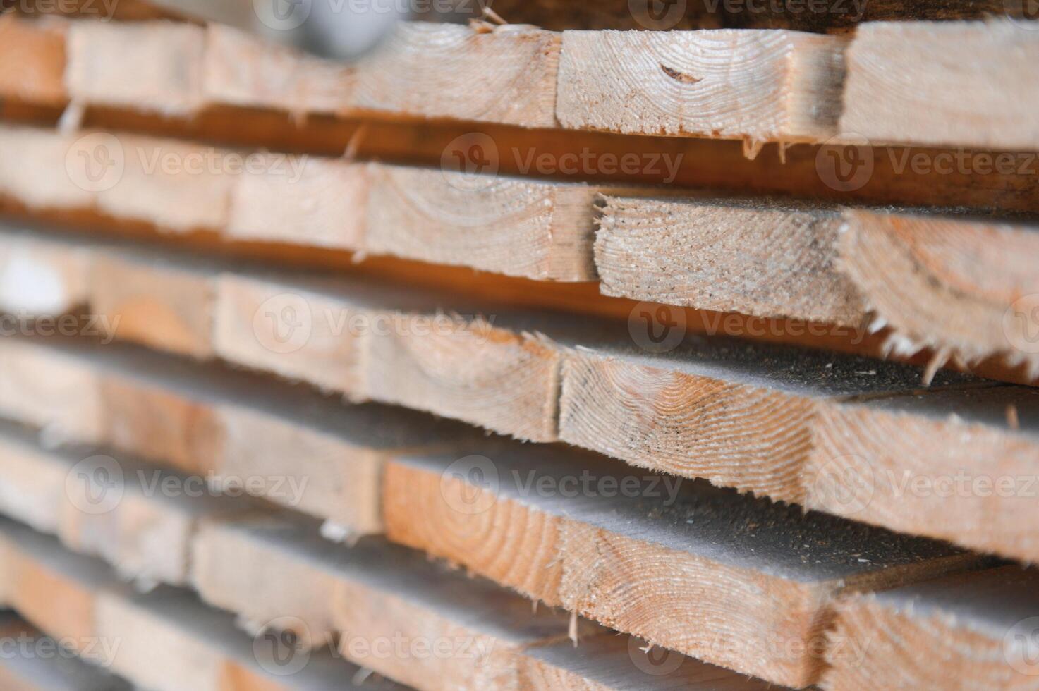 Stack of lumber of a wooden board from a tree, close-up, background. Wooden boards at the sawmill, carpentry workshop. Sawing and air drying of wood. Woodworking industry. Wooden boards photo