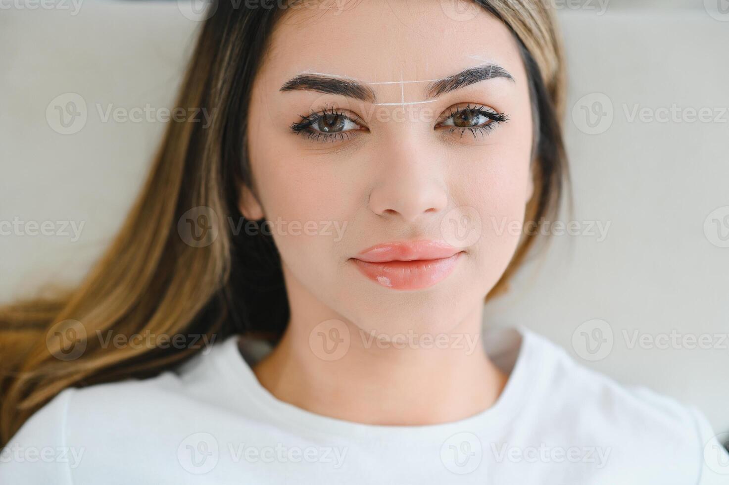 Young woman during professional eyebrow mapping procedure before permanent makeup photo