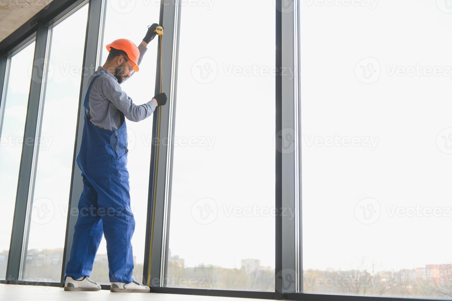 The foreman installs a window frame in the room photo