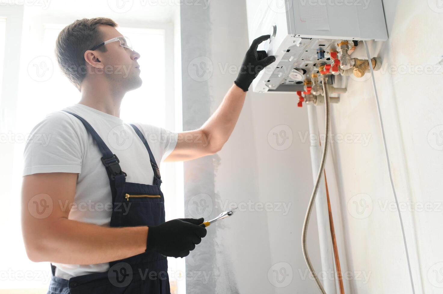 Professional plumber checking a boiler and pipes, boiler service concept photo
