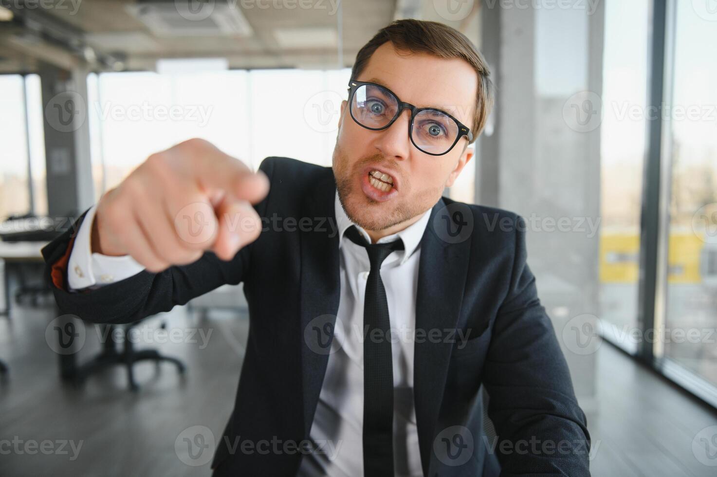 Angry businessman sitting at the table and screaming. photo