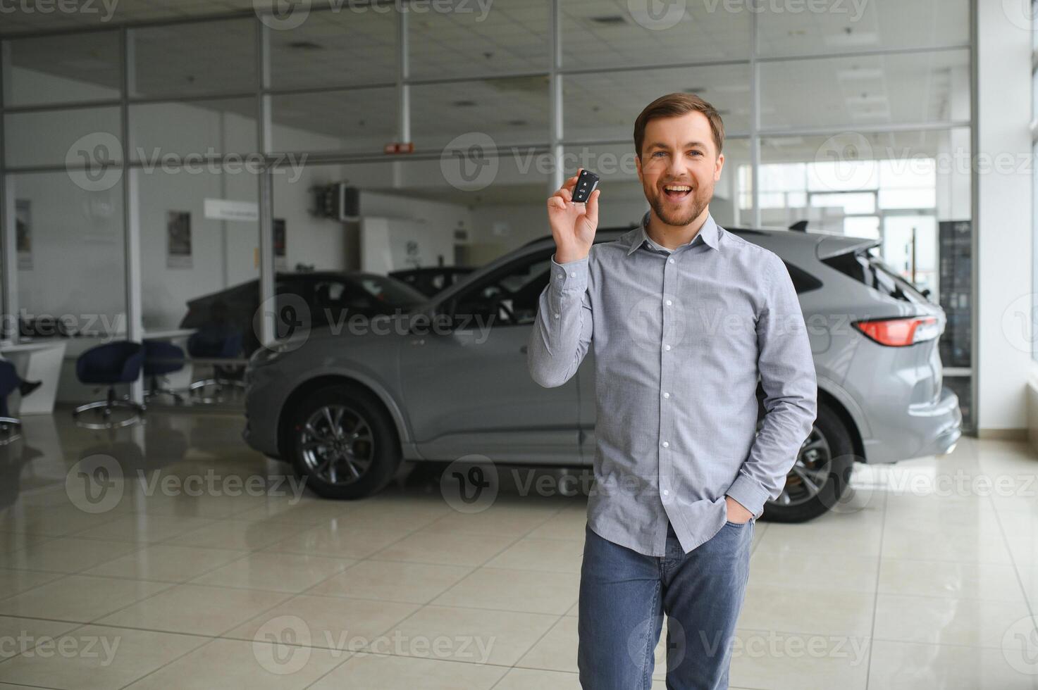 joven hombre es elegir un nuevo vehículo en coche concesión. foto