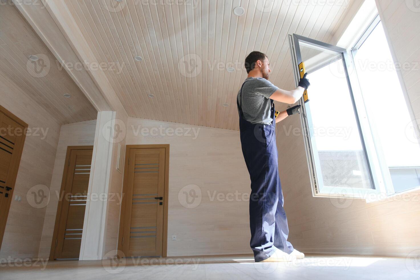 A worker installs windows in a new modular home. The concept of a new home. photo