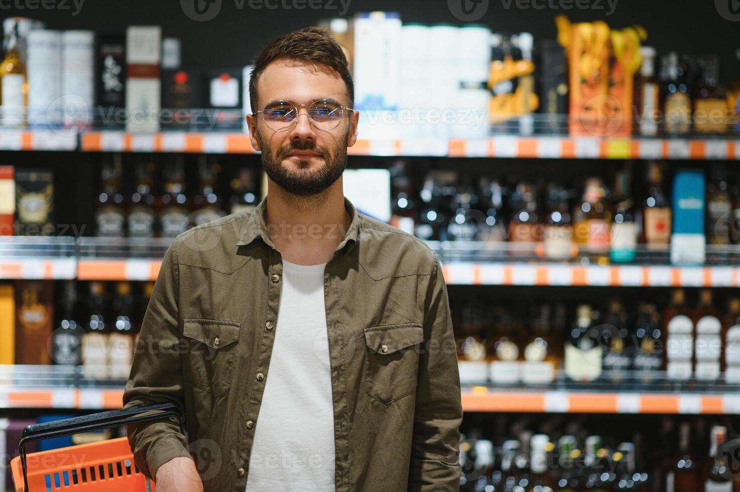 A man takes alcoholic drinks from the supermarket shelf. Shopping for alcohol in the store photo