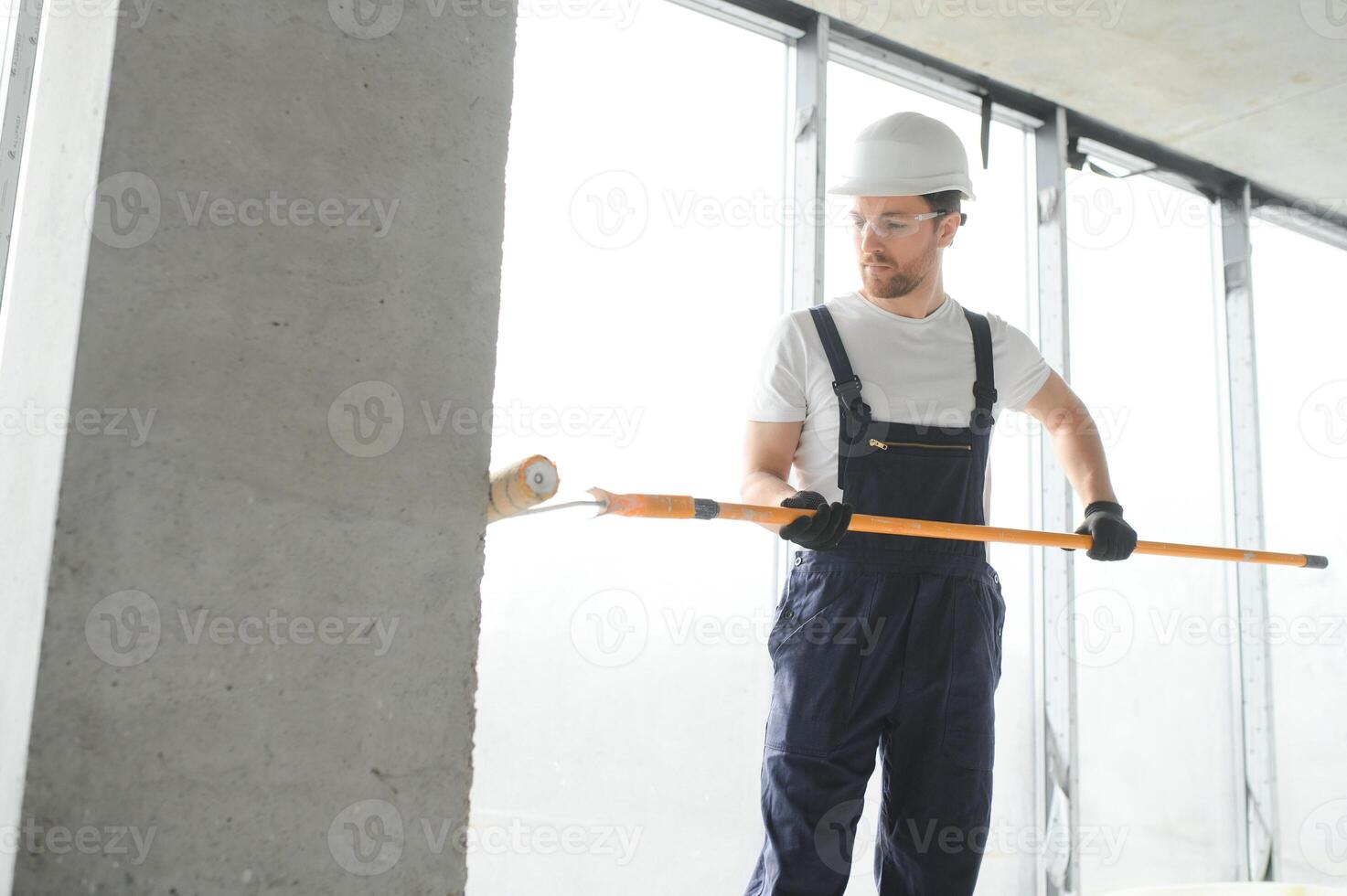 Worker renewing apartment on wall background. photo