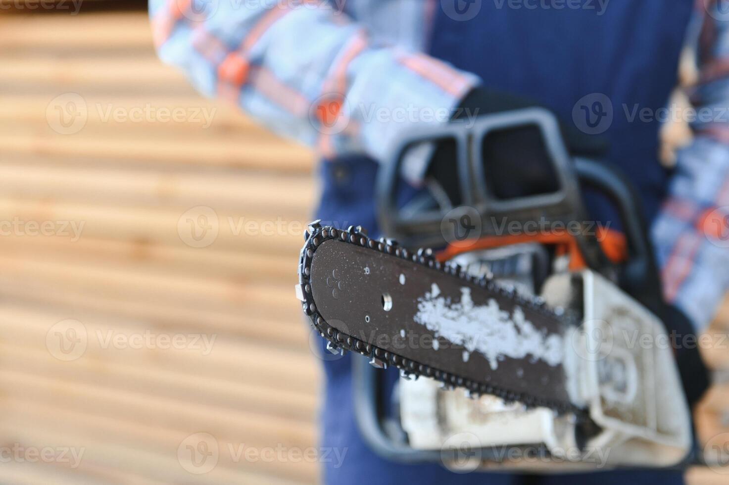 carpintero con un Sierra en su manos soportes en un antecedentes de cortar de madera tableros foto