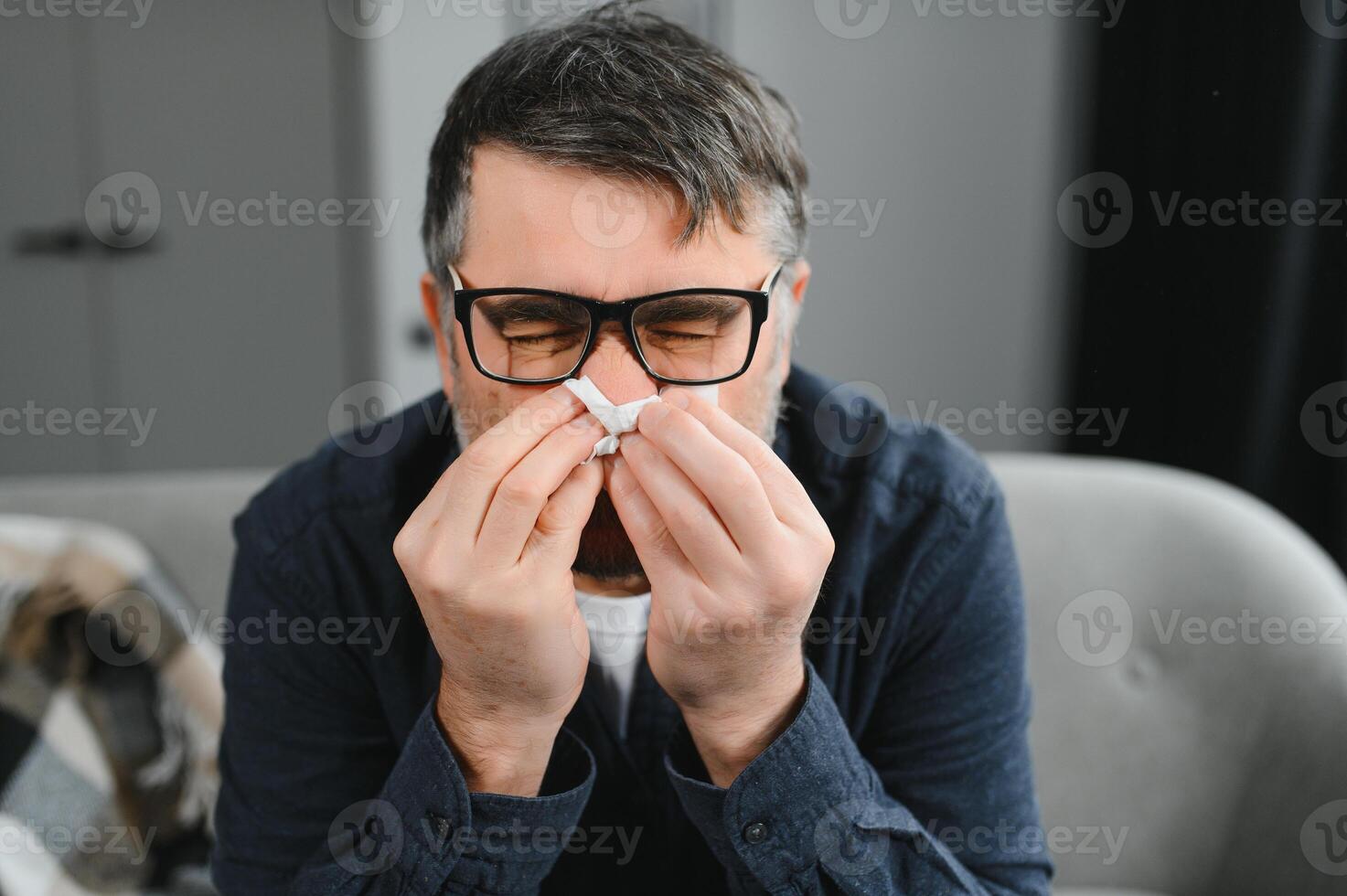 old man get a cold and sneeze with tissue paper at home photo