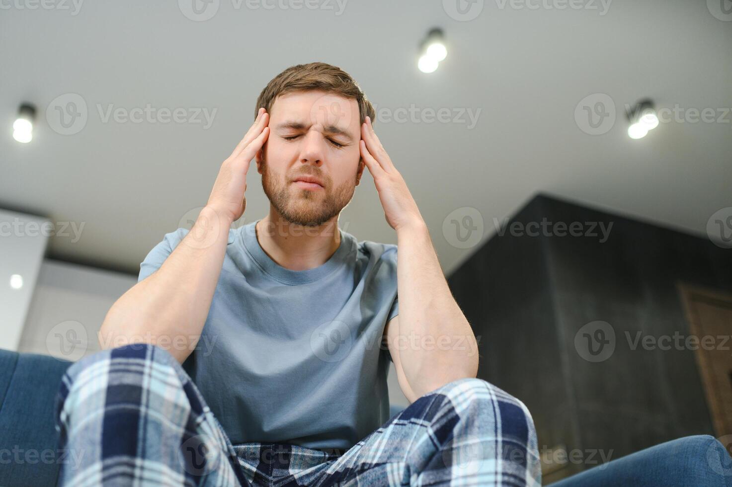 Morning of young man suffering from hangover at home photo
