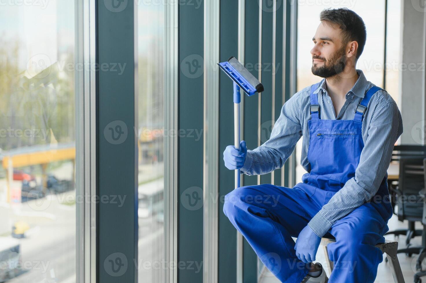 masculino portero limpieza ventana en oficina foto