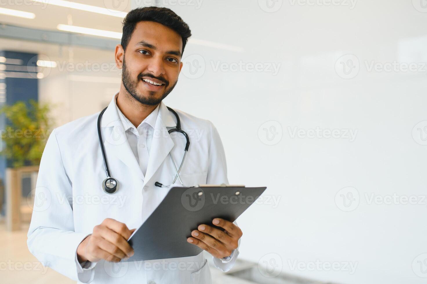 Portrait of confident Asian Indian medical doctor standing at hospital building photo