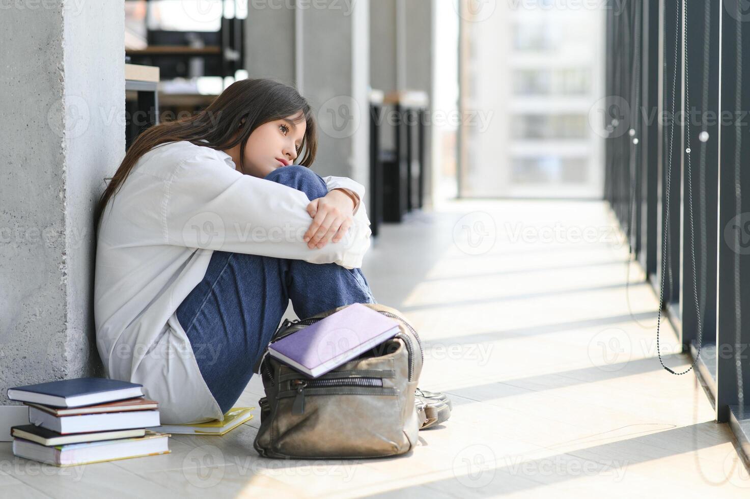 Lonely sad schoolgirl while all her classmates ignored her. Social exclusion problem. Bullying at school concept. photo