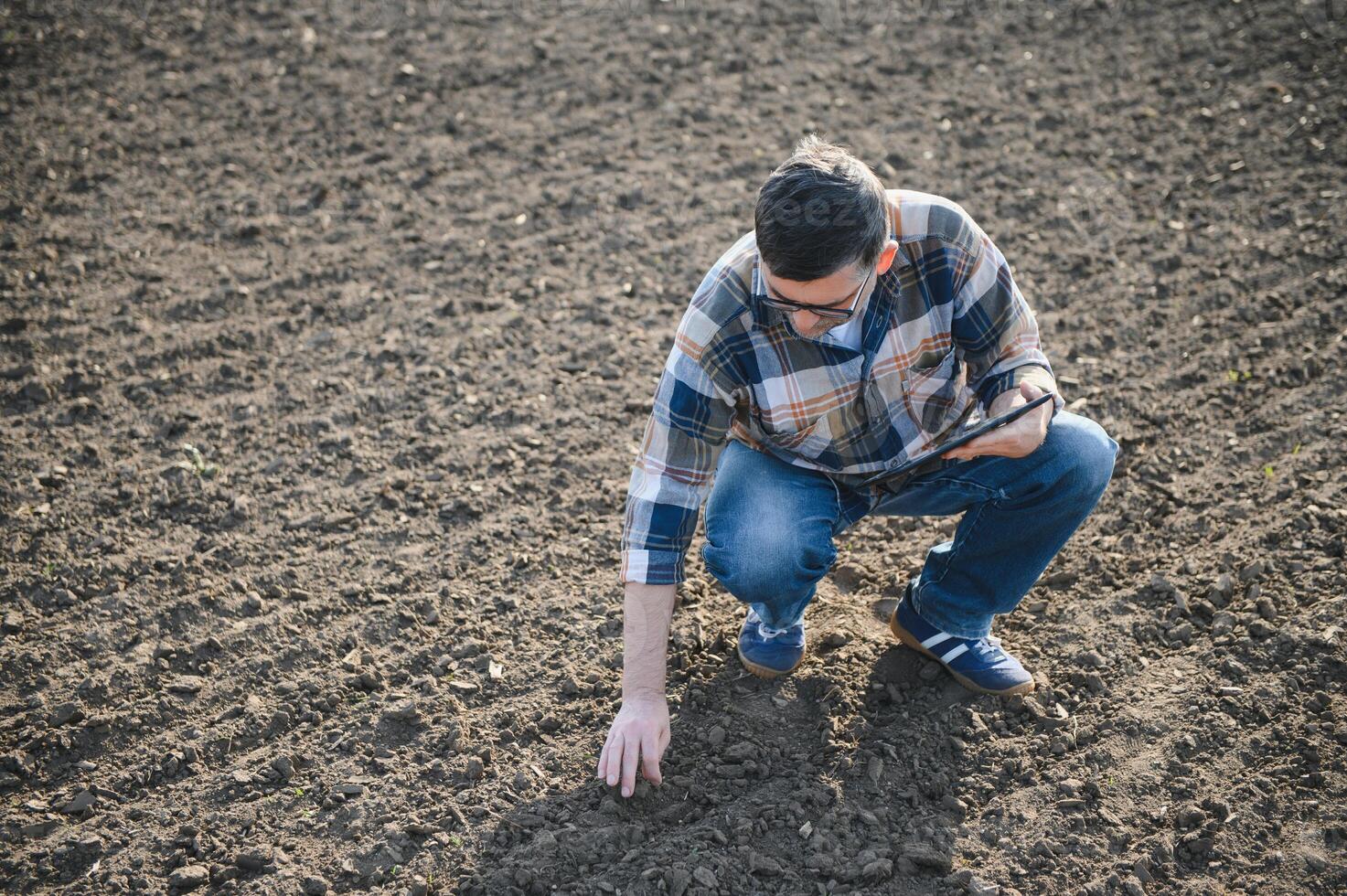 un granjero cheques calidad de suelo antes de siembra. foto