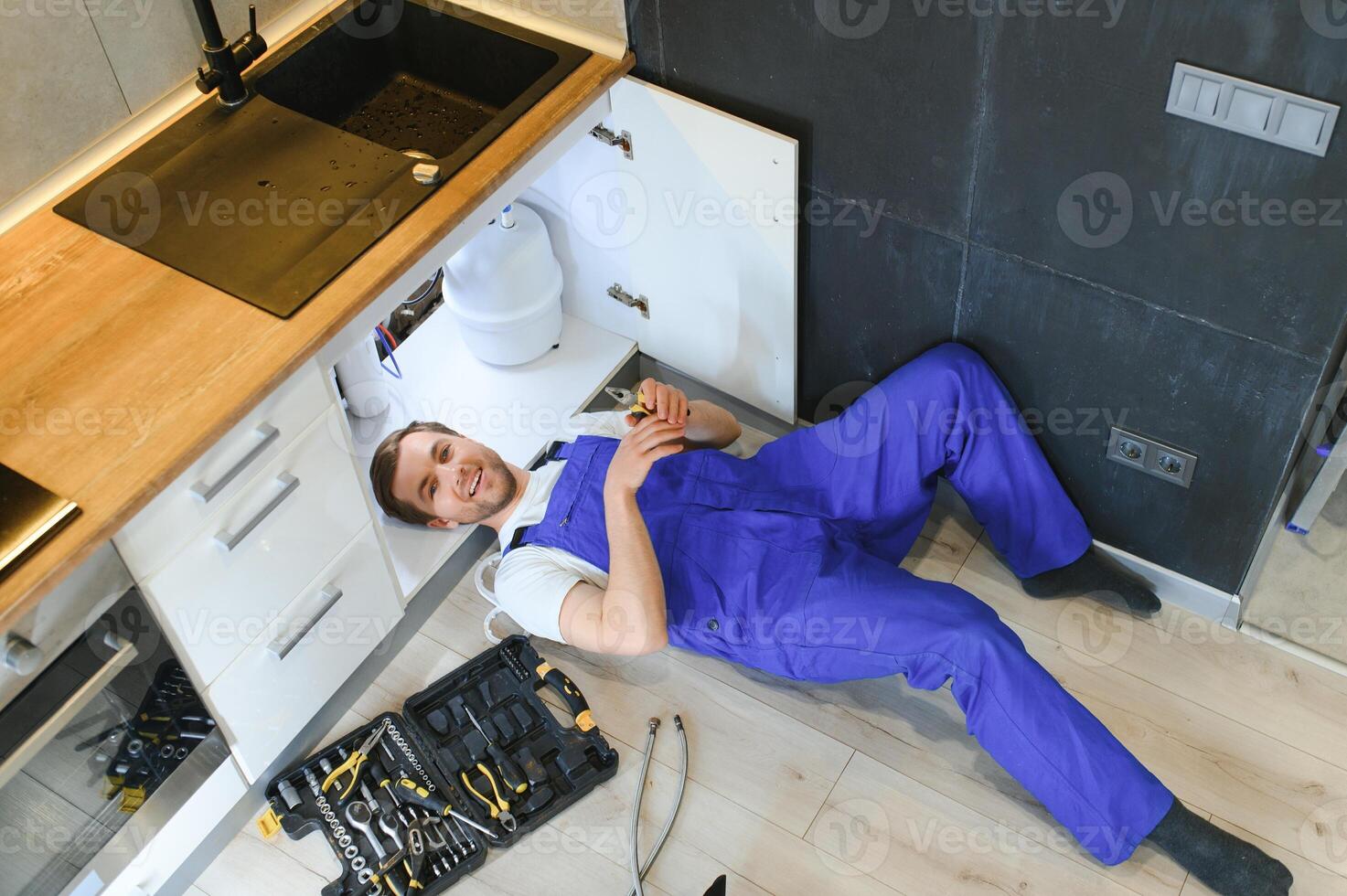 Plumber installs or change water filter. Replacement aqua filter. Repairman installing water filter cartridges in a kitchen. Installation of reverse osmosis water purification system. photo