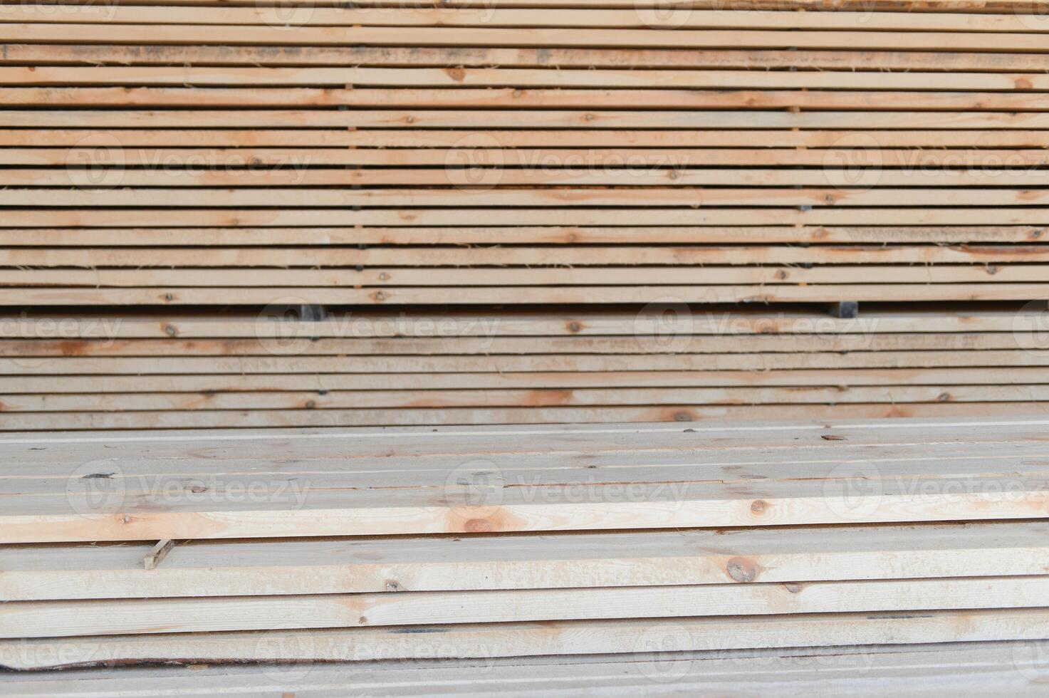 Stack of lumber of a wooden board from a tree, close-up, background. Wooden boards at the sawmill, carpentry workshop. Sawing and air drying of wood. Woodworking industry. Wooden boards photo