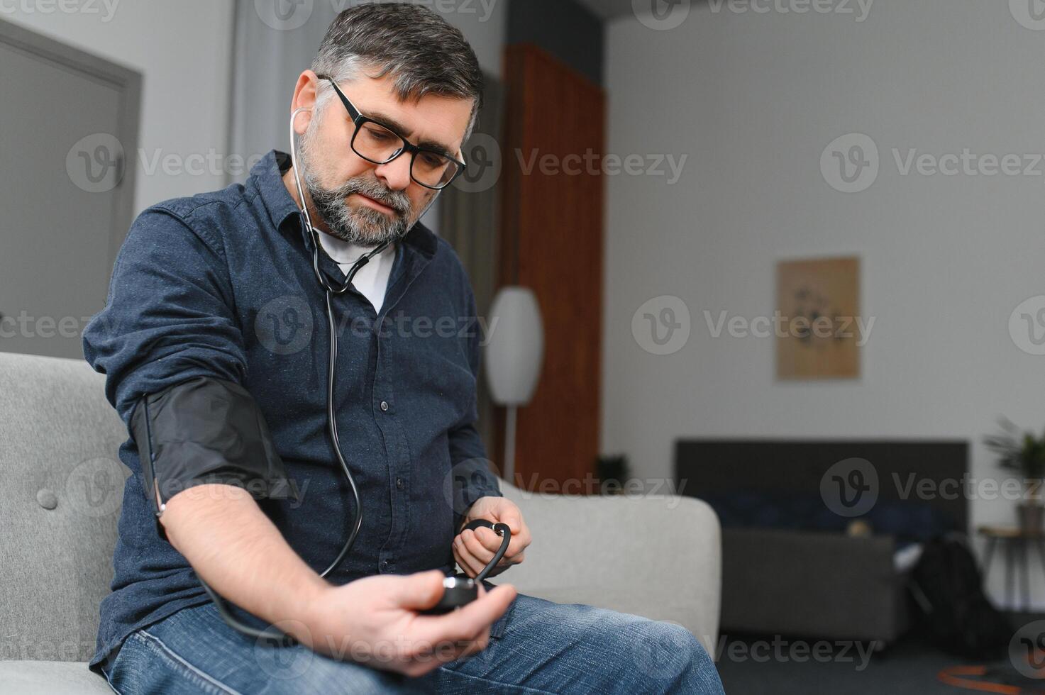 Senior man using medical device to measure blood pressure photo