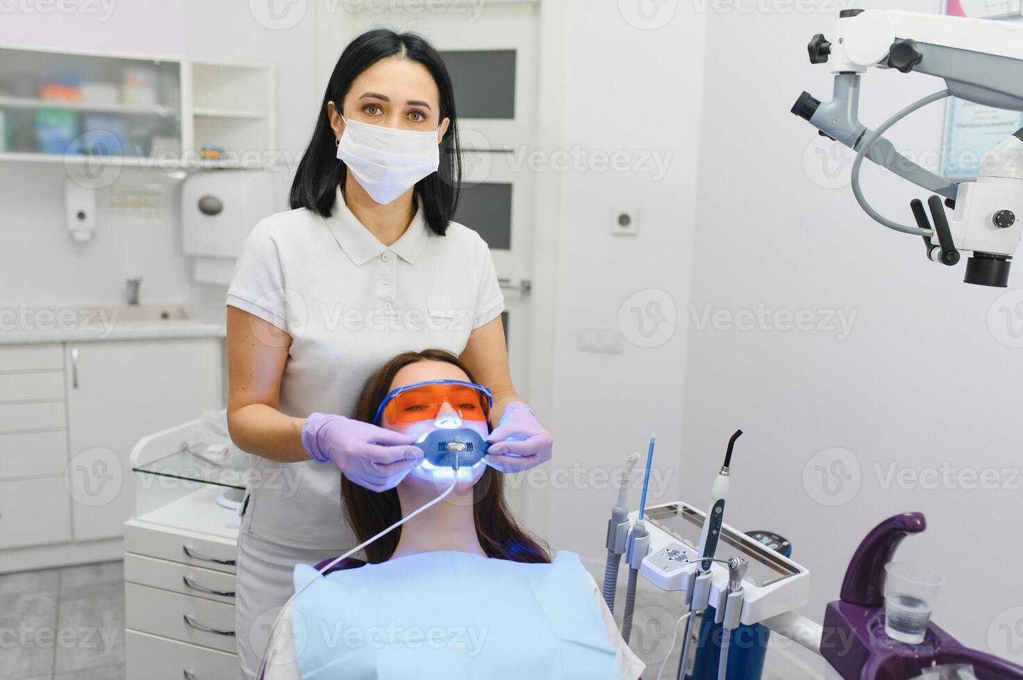 Teeth whitening for woman. Bleaching of the teeth at dentist clinic. photo