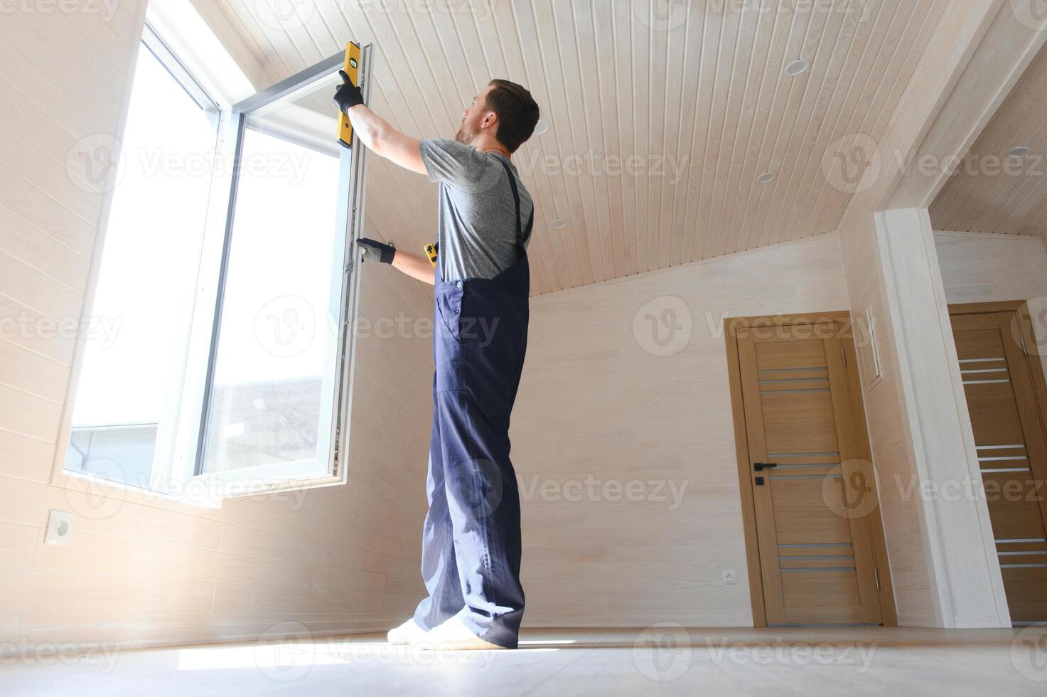 The worker installing and checking window in the house. Concept of new modular houses. photo