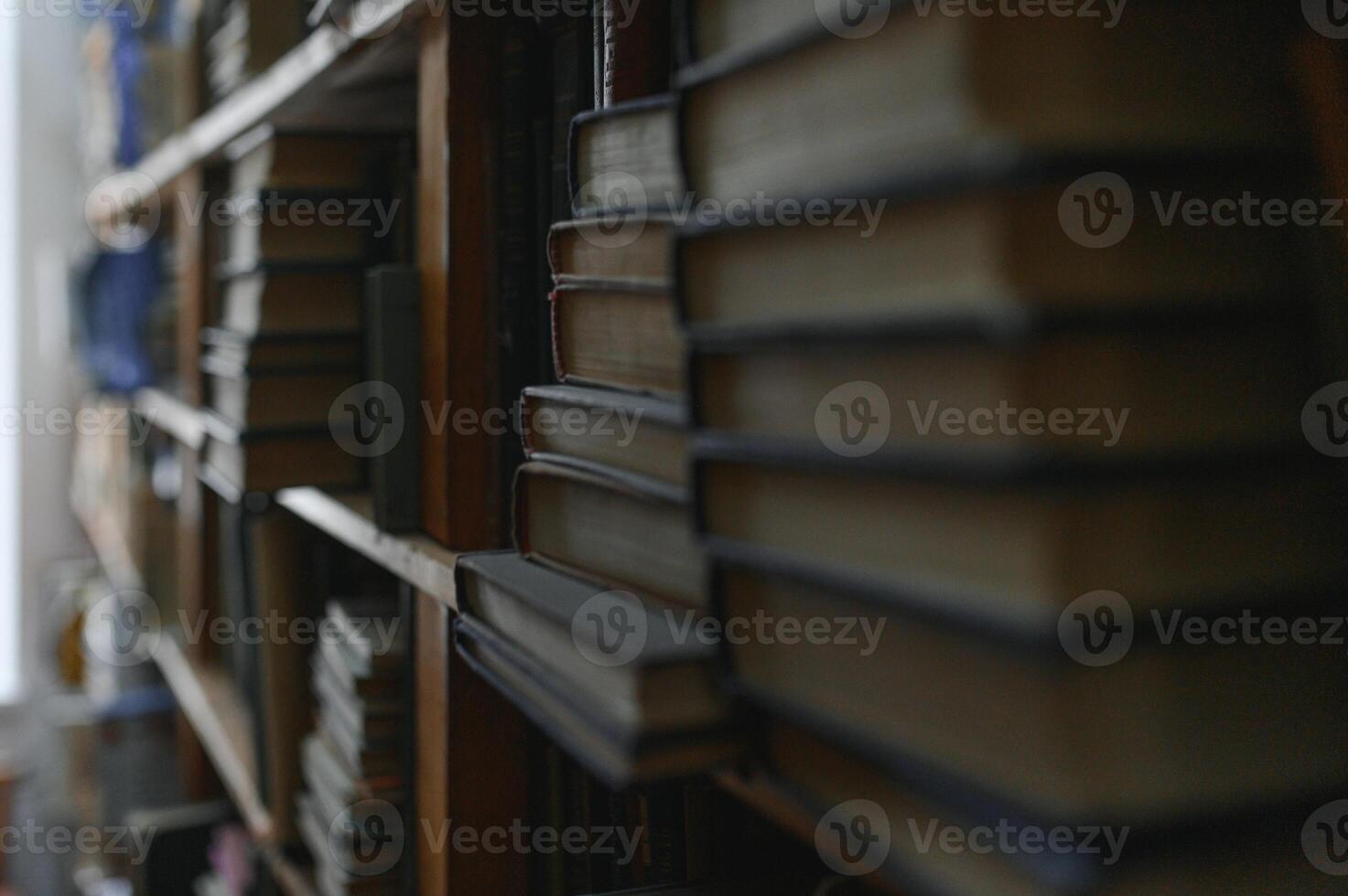 old books on shelves in archive blurred image, library photo
