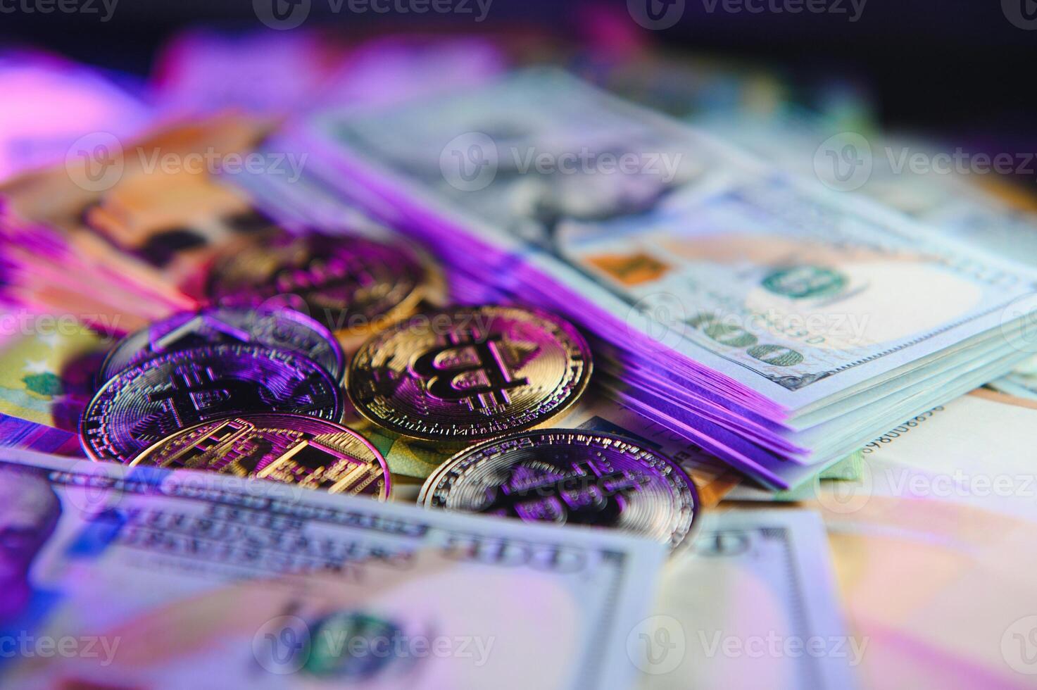 Close up heap of golden bitcoin physical coins on top of Euro, dollar banknotes background, high angle view, selective focus photo