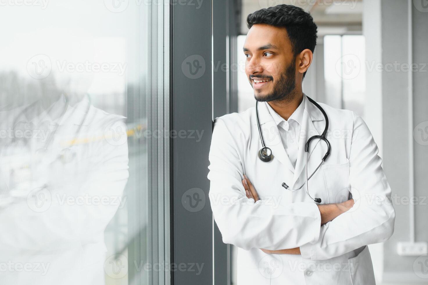 medicine, healthcare and people concept - happy male doctor with stethoscope and clipboard at clinic photo