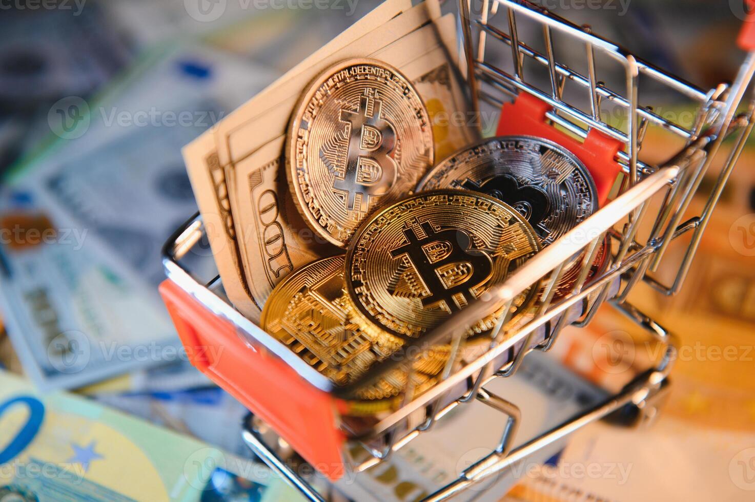 Close up heap of golden bitcoin physical coins on top of Euro, dollar banknotes background, high angle view, selective focus photo
